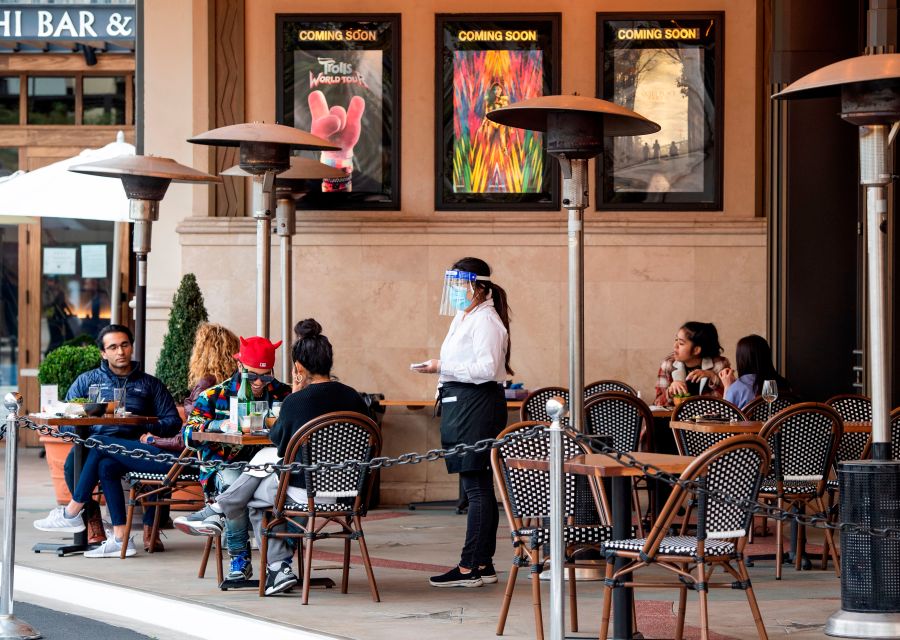 A waitress takes customers' orders in the outdoor seating area of a restaurant in Los Angeles on Jan. 28, 2021. (Valerie Macon / AFP / Getty Images)