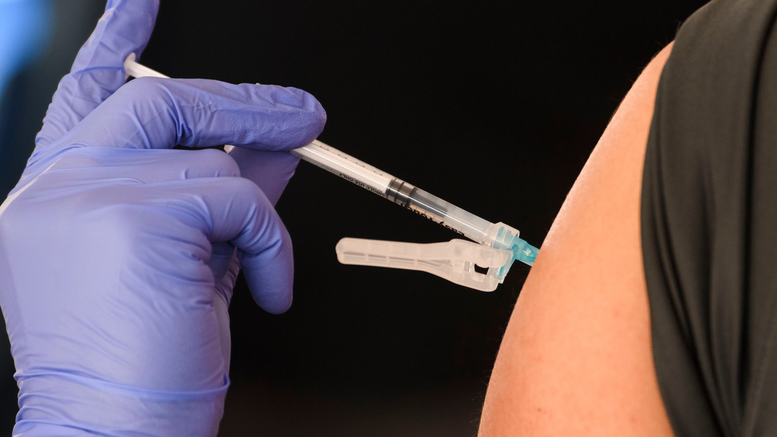 An education worker receives a vaccination at a mass vaccination site in a parking lot at Hollywood Park adjacent to SoFi stadium during the Covid-19 pandemic on March 1, 2021 in Inglewood, California. (Photo by Patrick T. FALLON / AFP)