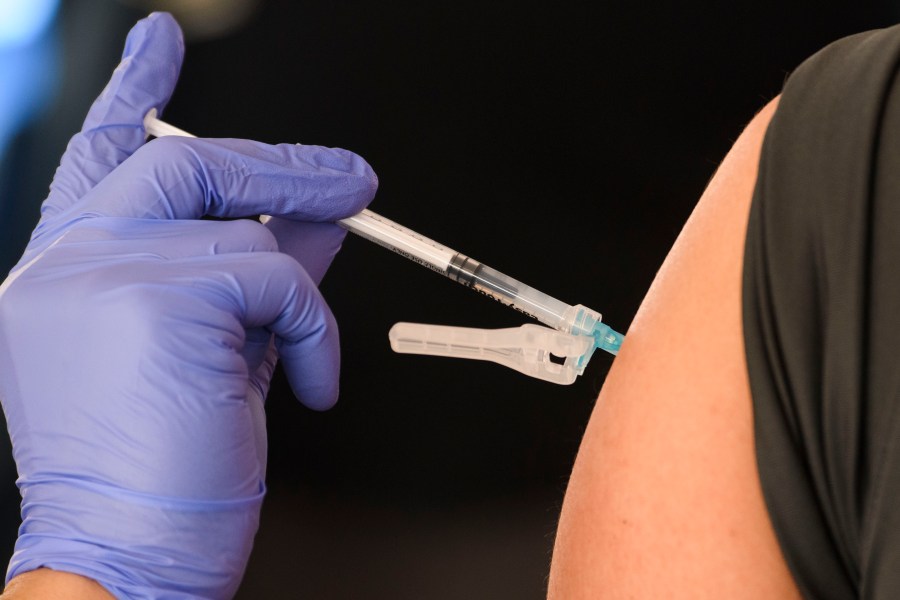 An education worker receives a vaccination at a mass vaccination site in a parking lot at Hollywood Park adjacent to SoFi stadium during the Covid-19 pandemic on March 1, 2021 in Inglewood, California. (Photo by Patrick T. FALLON / AFP)