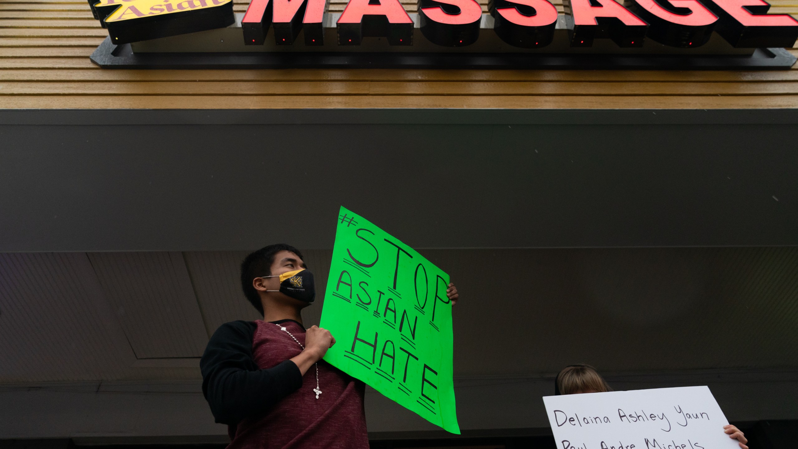 Jesus Estrella holds a sign of solidarity outside Youngs Asian Massage where four people were shot and killed on March 17, 2021 in Acworth, Georgia. (Elijah Nouvelage/Getty Images)