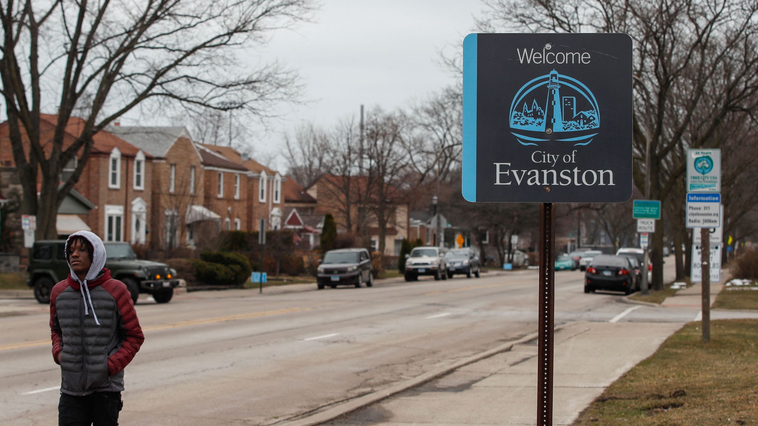 A man walks by a sign welcoming people to the city of in Evanston, Illinois, on March 16, 2021. (Kamil Krzaczynski /AFP / Getty Images)