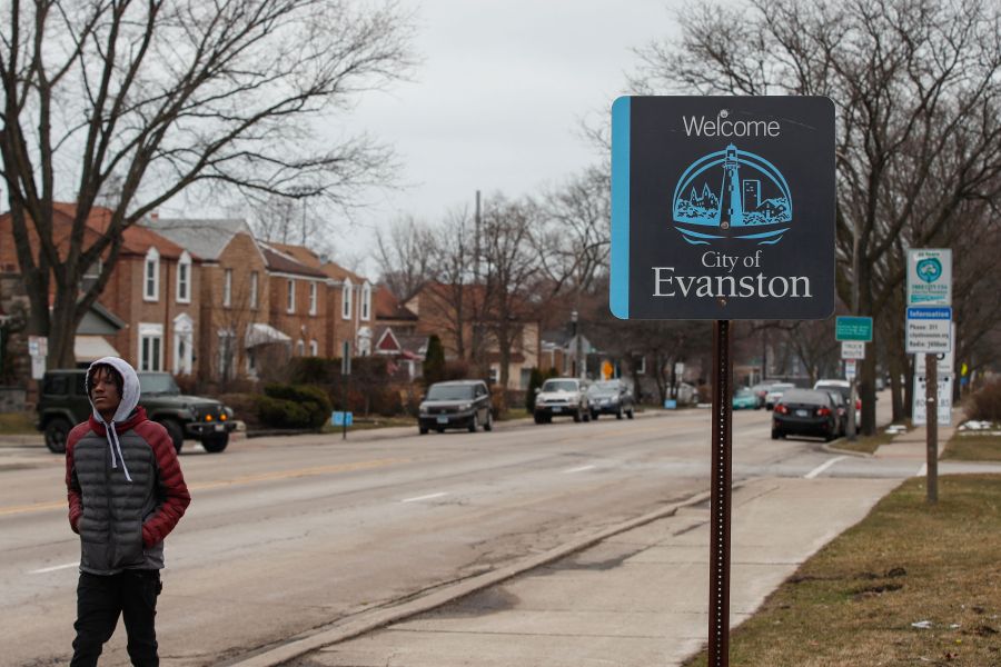 A man walks by a sign welcoming people to the city of in Evanston, Illinois, on March 16, 2021. (Kamil Krzaczynski /AFP / Getty Images)