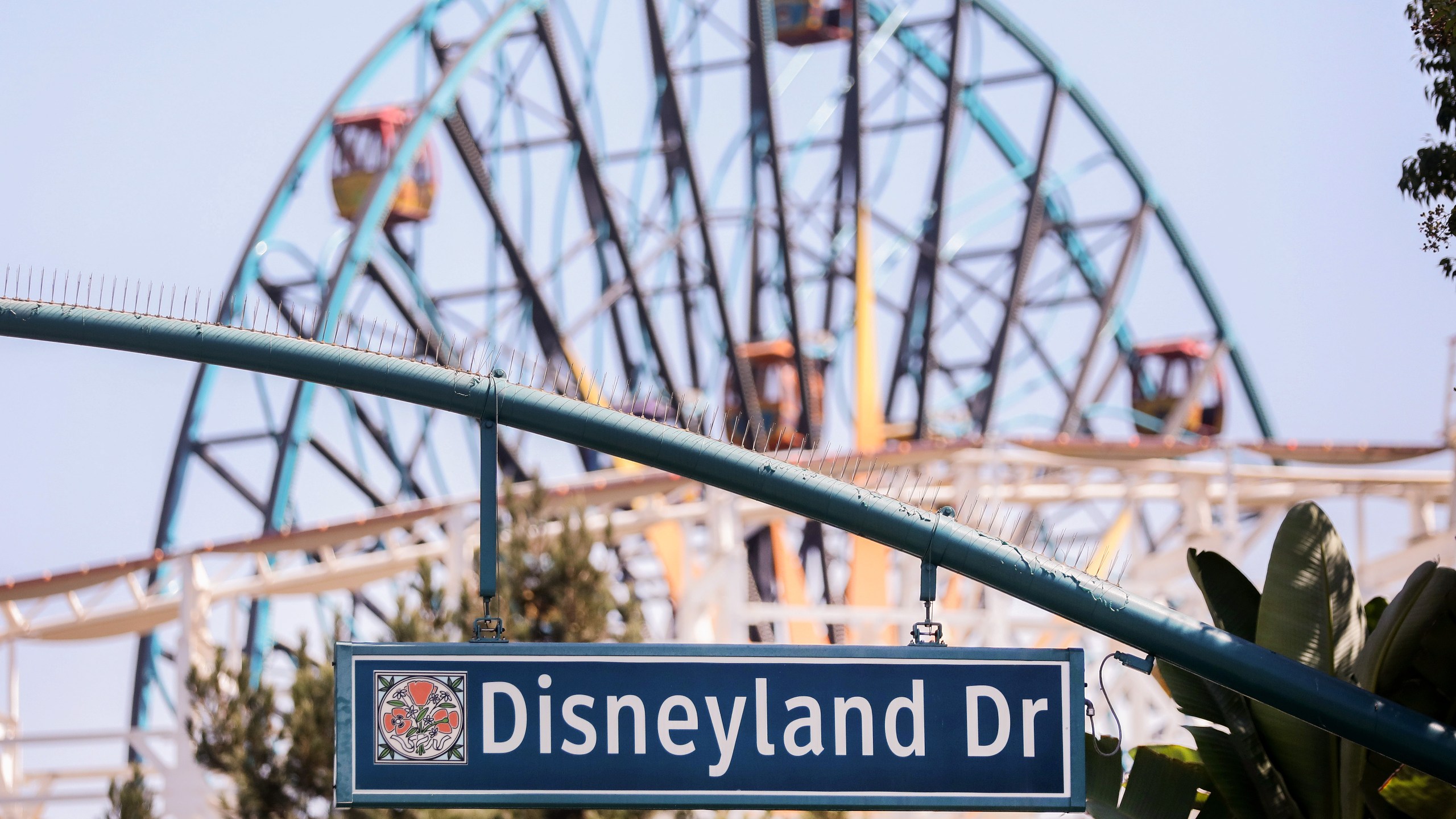 A sign for Disneyland Drive hangs near empty amusement rides on Sept. 30, 2020, in Anaheim, California.(Mario Tama/Getty Images)