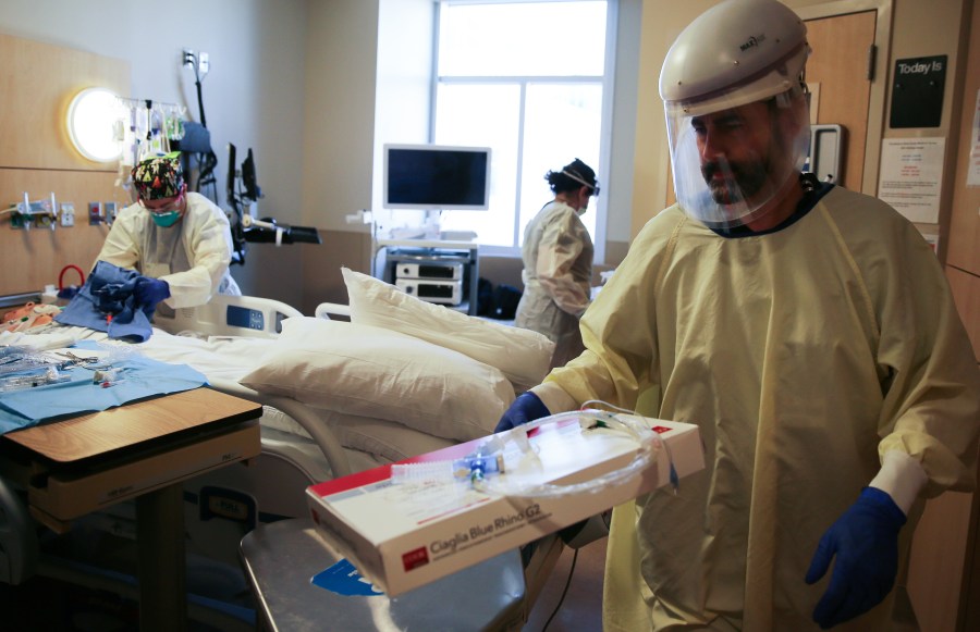 Clinicians work after performing a tracheostomy on a patient in a COVID-19 ICU at Providence Holy Cross Medical Center in Mission Hills on Feb. 17, 2021. (Mario Tama/Getty Images)