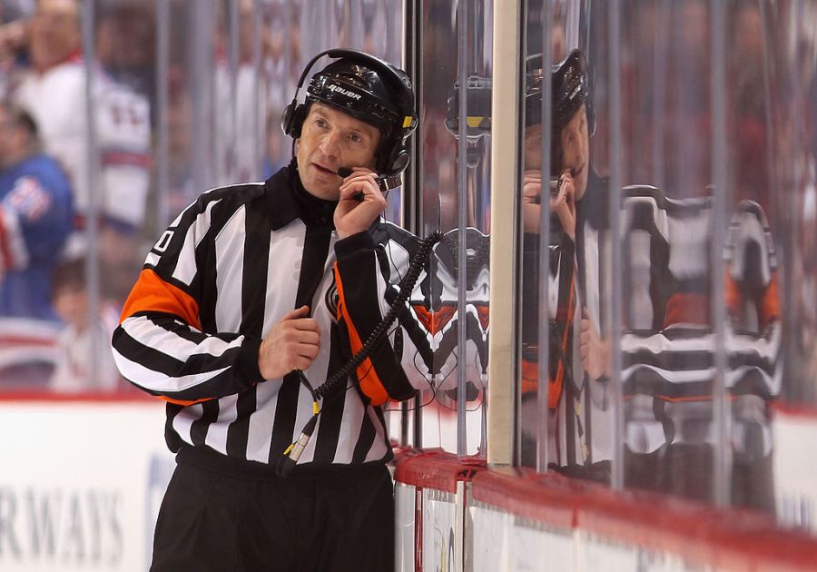 Referee Tim Peel talks with NHL officials in Toronto as they review a goal on December 17, 2011 in Glendale, Arizona. (Photo by Christian Petersen/Getty Images)