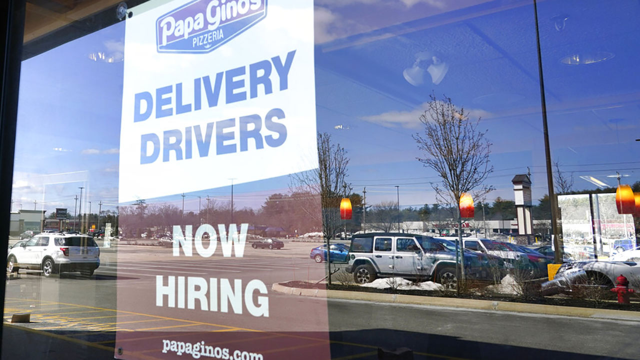 A "Now Hiring" sign is displayed, Thursday, March 4, 2021, in Salem, N.H. After a year of ghostly airports, empty sports stadiums and constant Zoom meetings, growing evidence suggests that the economy is strengthening. (AP Photo/Elise Amendola)