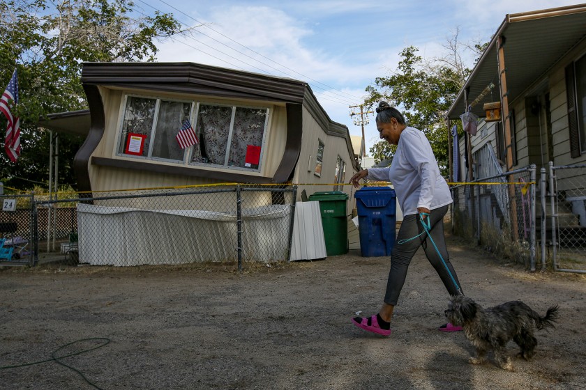 Carmen Rivera and her dog Ash pass by a dislodged mobile home following the Ridgecrest, Calif., earthquake in 2019. A new study suggests the long-awaited Big One may do less damage to the Los Angeles area than previously thought.(Irfan Khan / Los Angeles Times)