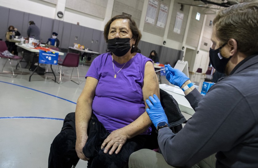 Eloisa Campos, 70, receives her second shot of the Pfizer vaccine in Santa Ana. “I’m excited,” she said later in Spanish. “I’m going to be safe.” (Brian van der Brug / Los Angeles Times)