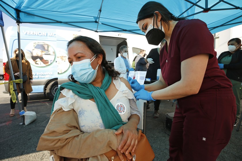 Cristina Vasquez receives a COVID-19 vaccine from physician assistant’s Alyssa Hernandez in Vernon on March 17, 2021. (Al Seib / Los Angeles Times)