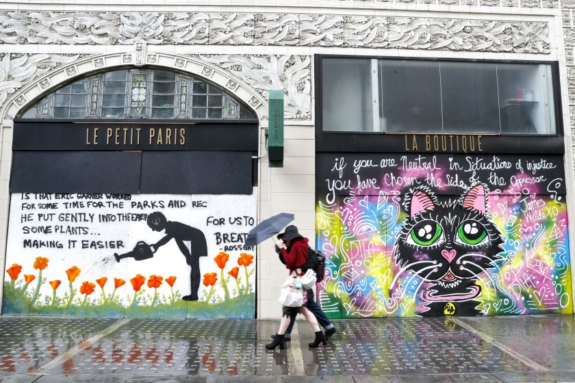 A couple share an umbrella while walking along Spring Street in downtown Los Angeles on Feb. 4.(Jay L. Clendenin/Los Angeles Times)