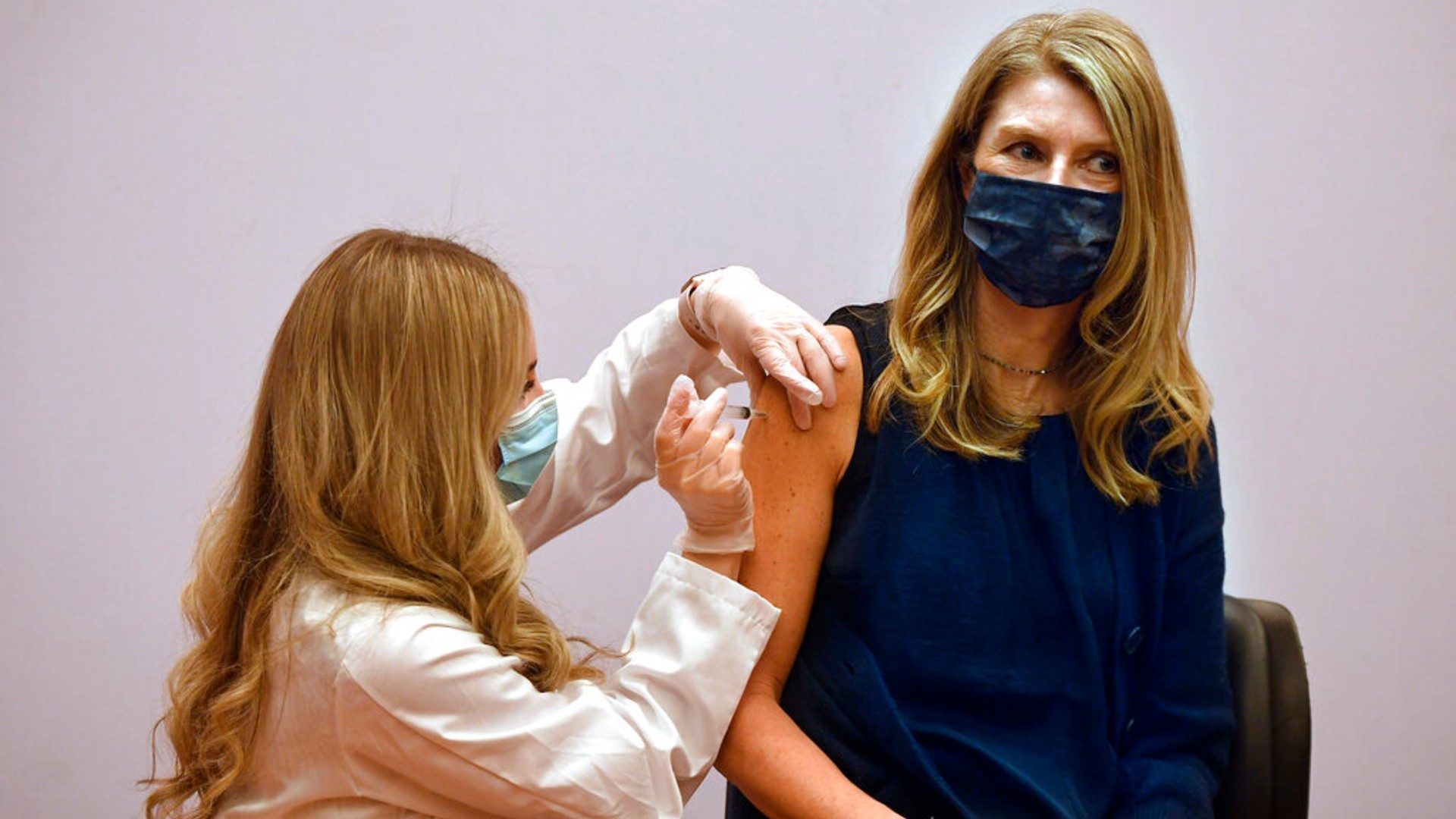 Granby kindergarten school teacher Christina Kibby receives the Johnson & Johnson COVID-19 vaccine by pharmacist Madeline Acquilano, left, at Hartford Hospital in Hartford, Conn. (AP Photo/Jessica Hill)