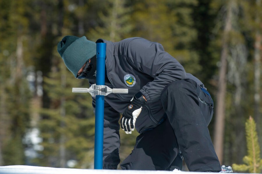 Sean de Guzman, chief of snow surveys for the California Department of Water Resources, checks the depth of the snowpack during the second snow survey of the season at Phillips Station near Echo Summit, Calif., Tuesday, March 2, 2021. (AP Photo/Randall Benton)