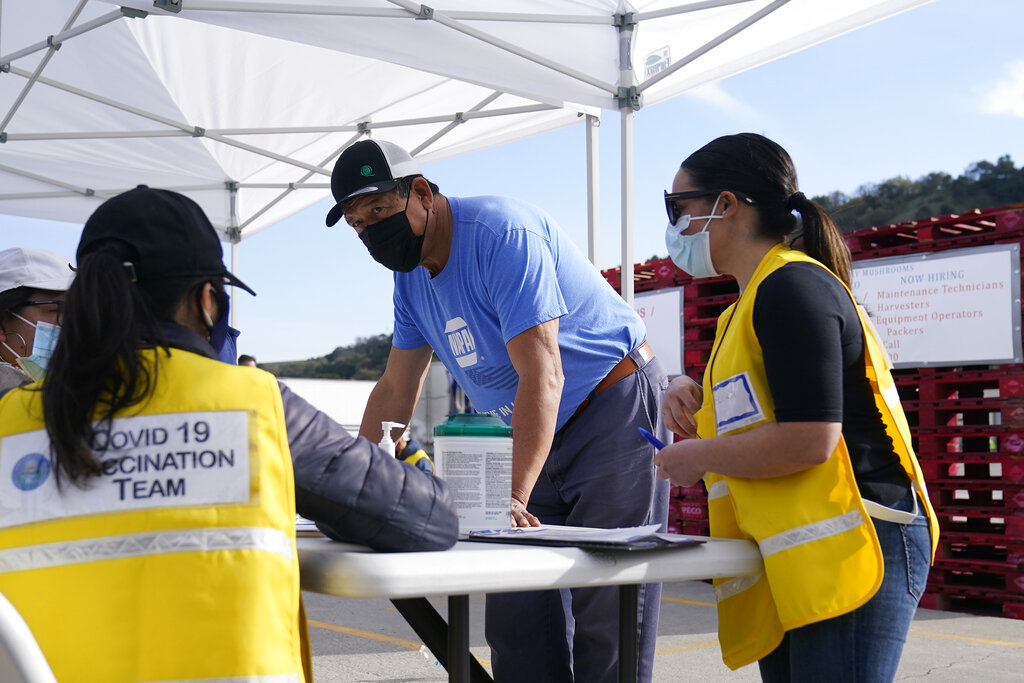 A farmworker checks in before receiving the Moderna COVID-19 vaccine at a County of Santa Clara mobile vaccination clinic on March 3, 2021. (AP Photo/Jeff Chiu)