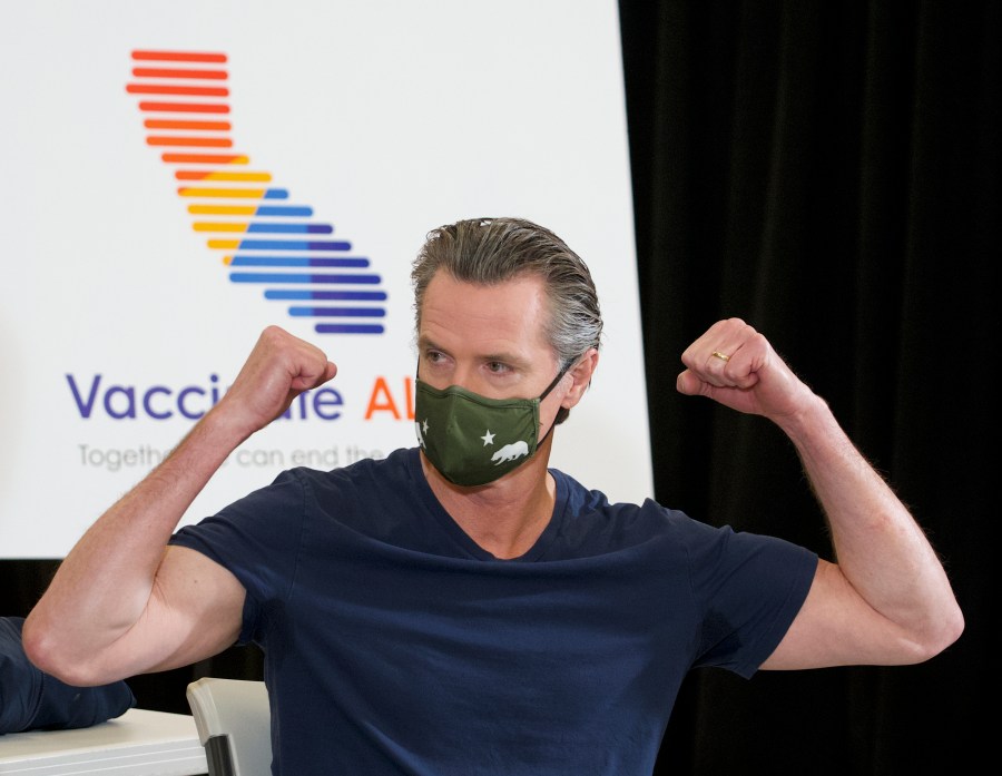 California Gov. Gavin Newsom reacts after being inoculated by Dr. Mark Ghaly, Secretary of California Health and Human Services, with the new one-dose Janssen COVID-19 vaccine at the Baldwin Hills Crenshaw Plaza in Los Angeles on April 1, 2021. (AP Photo/Damian Dovarganes)