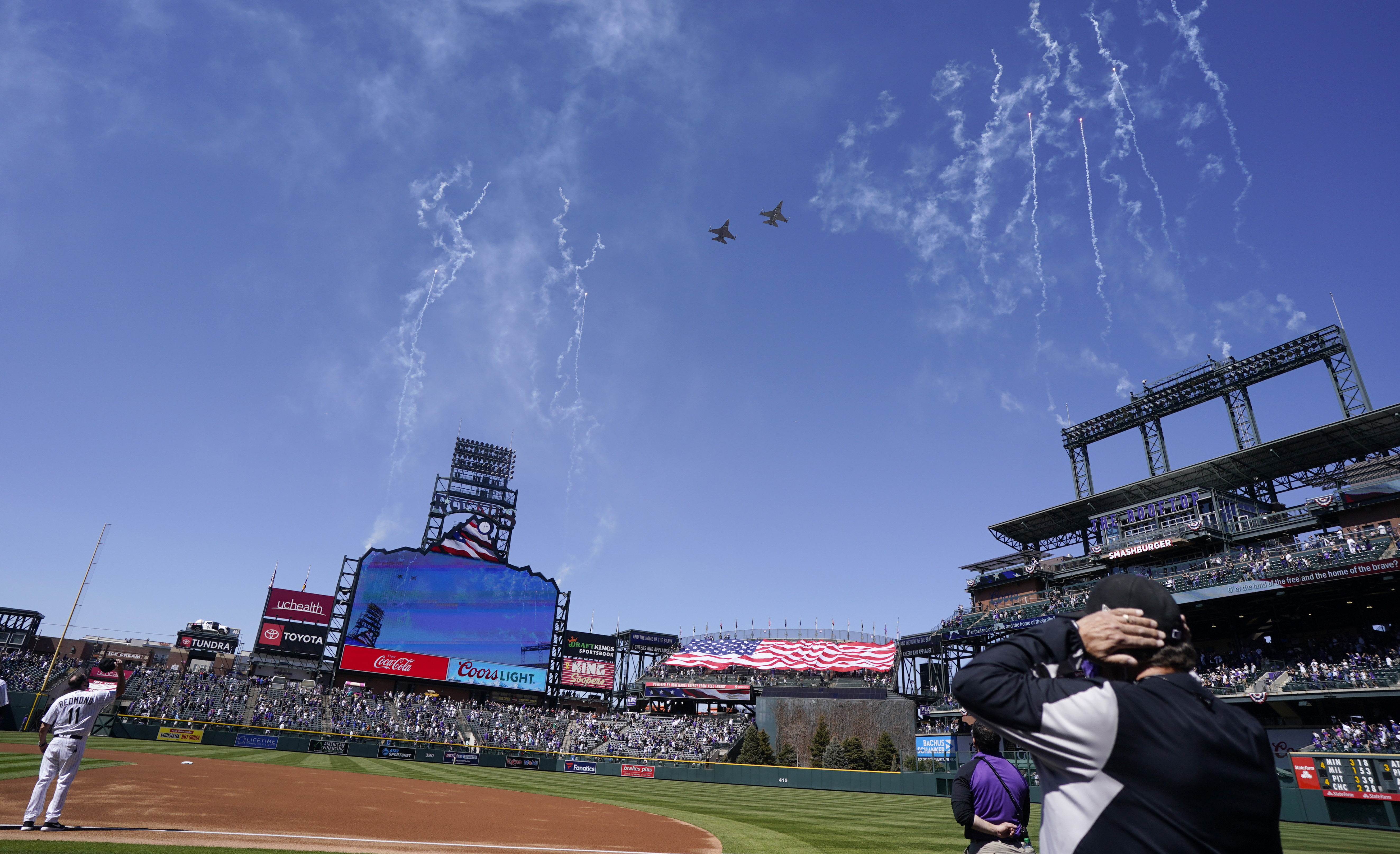 Two F-16 jets from Buckley Air Force Base in Aurora, Colo., fly over Coors Field before a baseball game between the Los Angeles Dodgers and the Colorado Rockies on opening day, Thursday, April 1, 2021, in Denver. (AP Photo/David Zalubowski)