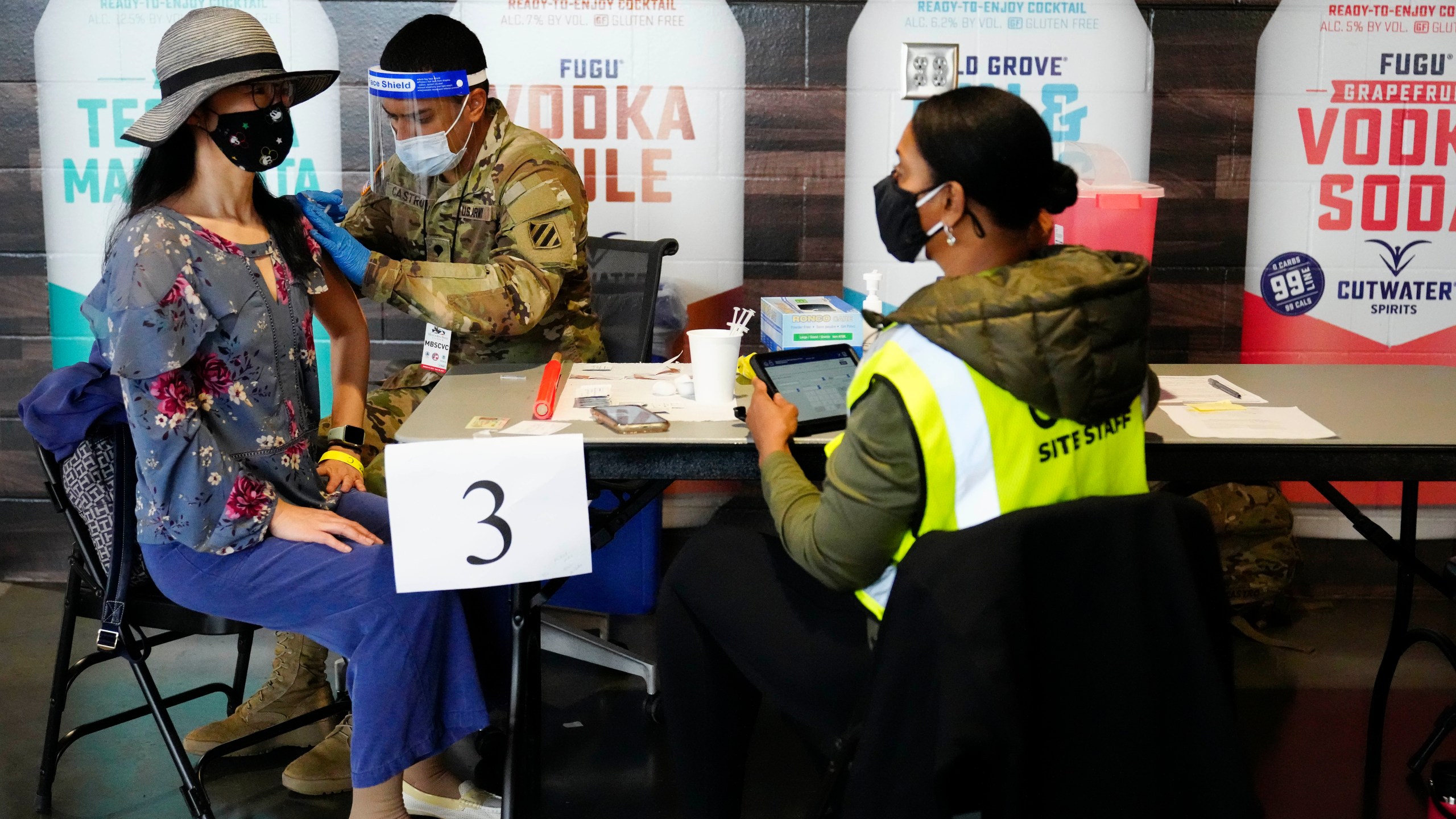 In this March 25, 2021, file photo, Jing Wang, left, receives a vaccine at Mercedes-Benz Stadium in Atlanta. (AP Photo/Brynn Anderson, File)