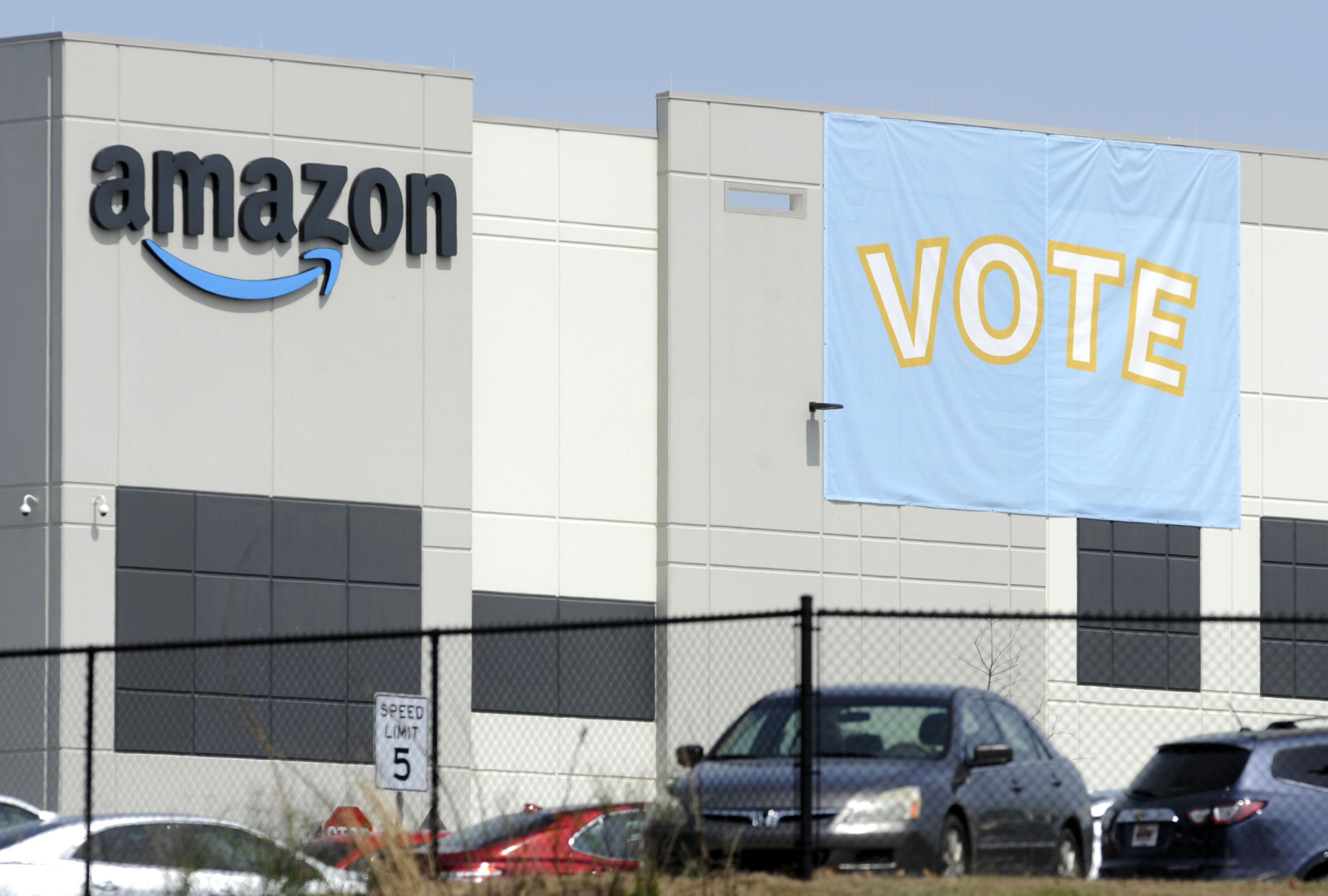 In this Tuesday, March 30, 2021 file photo, a banner encouraging workers to vote in labor balloting is shown at an Amazon warehouse in Bessemer, Ala. (AP Photo/Jay Reeves, File)