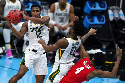 Baylor guard Jared Butler (12) passes over teammate guard Adam Flagler (10) and Houston forward Justin Gorham (4) during the first half of a men's Final Four NCAA college basketball tournament semifinal game, Saturday, April 3, 2021, at Lucas Oil Stadium in Indianapolis. (AP Photo/Michael Conroy)