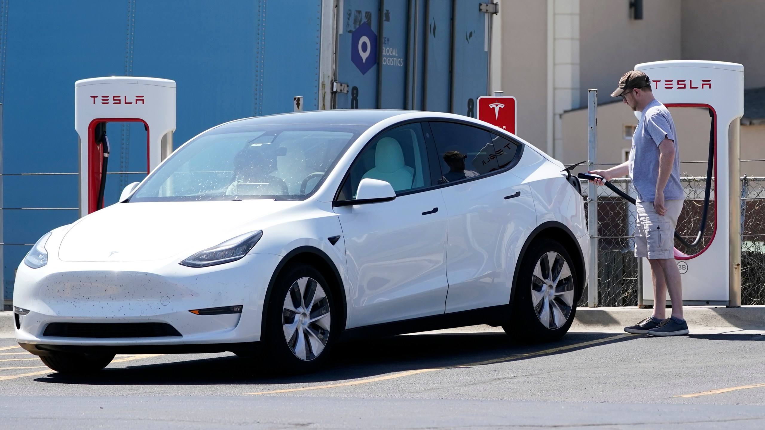 A Tesla owner charges his vehicle at a charging station in Topeka, Kan., Monday, April 5, 2021. (AP Photo/Orlin Wagner)