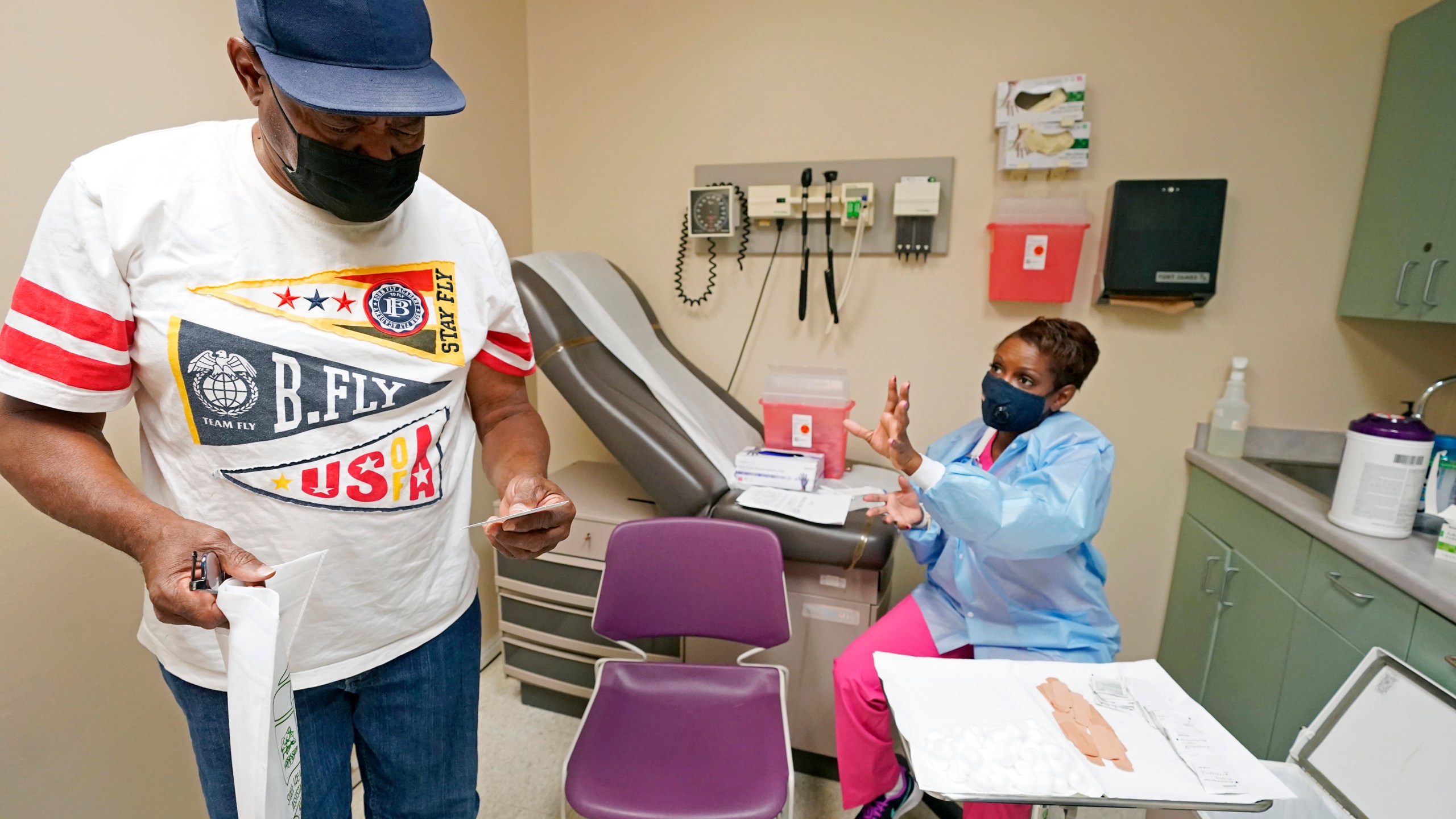 Wilbert Marshall, 71, looks at his shot card after receiving the COVID-19 vaccine from Melissa Banks, right, a nurse at the Aaron E. Henry Community Health Service Center in Clarksdale, Miss., Wednesday, April 7, 2021. (AP Photo/Rogelio V. Solis)