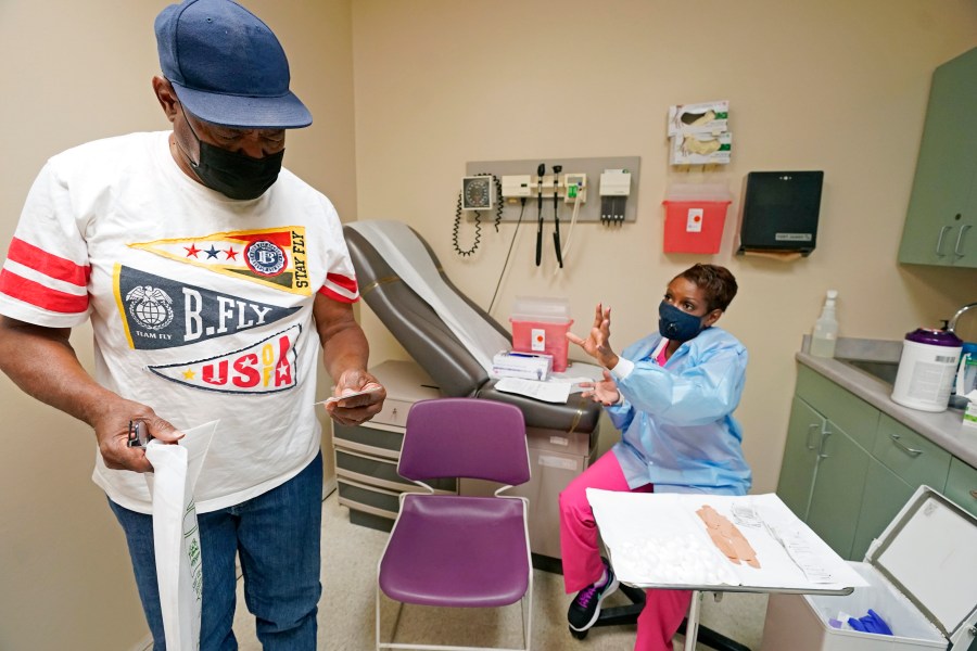 Wilbert Marshall, 71, looks at his shot card after receiving the COVID-19 vaccine from Melissa Banks, right, a nurse at the Aaron E. Henry Community Health Service Center in Clarksdale, Miss., Wednesday, April 7, 2021. (AP Photo/Rogelio V. Solis)