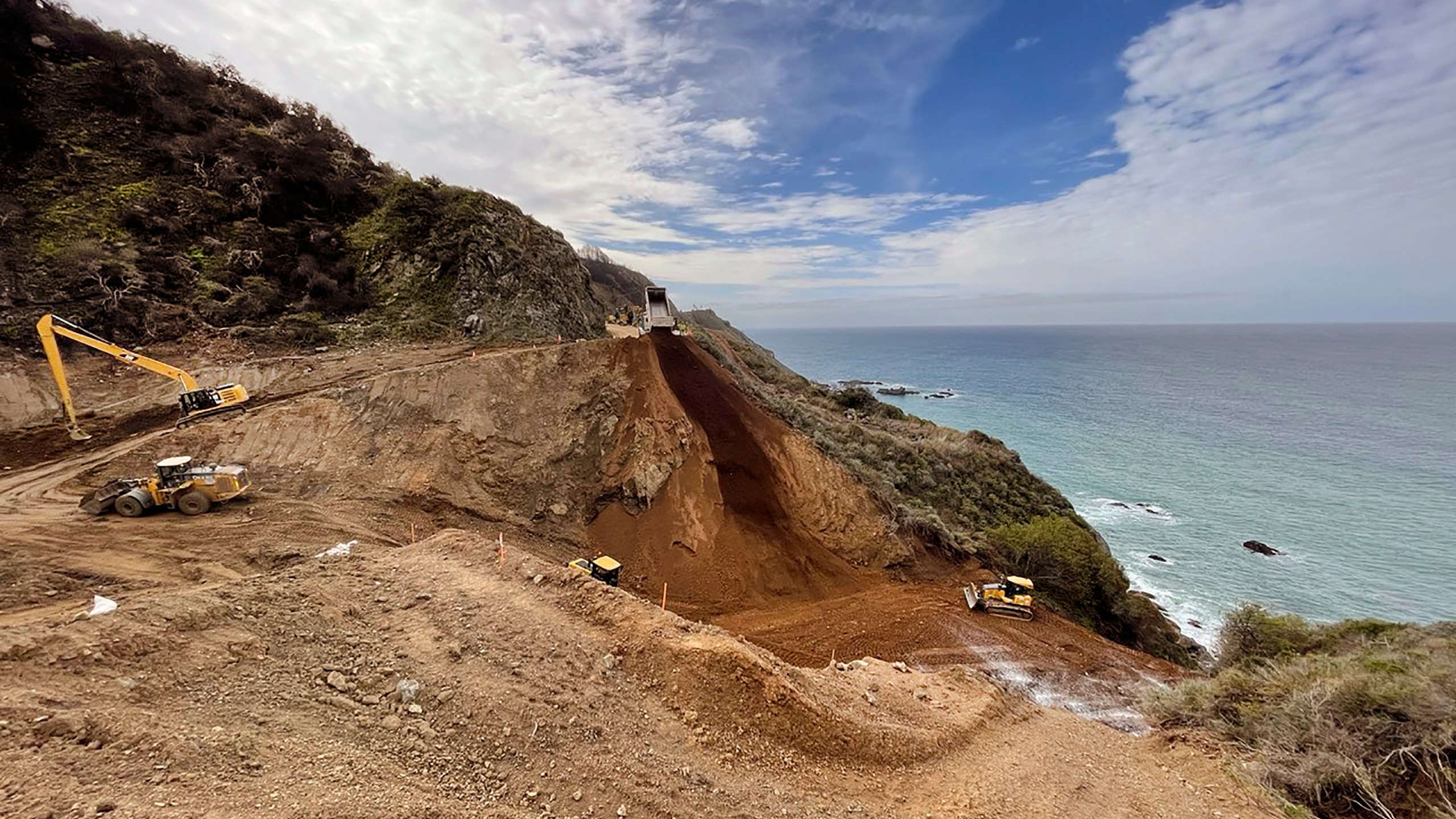 In this April 8, 2021, photo provided by the California Department of Transportation, a Caltrans construction crew repairs a section of Highway 1 along the Pacific Ocean in Big Sur, that was washed away during a winter storm on Jan. 28, 2021. The stretch of road is expected to reopen by April 30, 2021, because work to repair the huge piece of roadway that crumbled during a storm is nearly two months ahead of schedule, the California Department of Transportation announced Thursday, April 8. (Caltrans District 5 via AP)