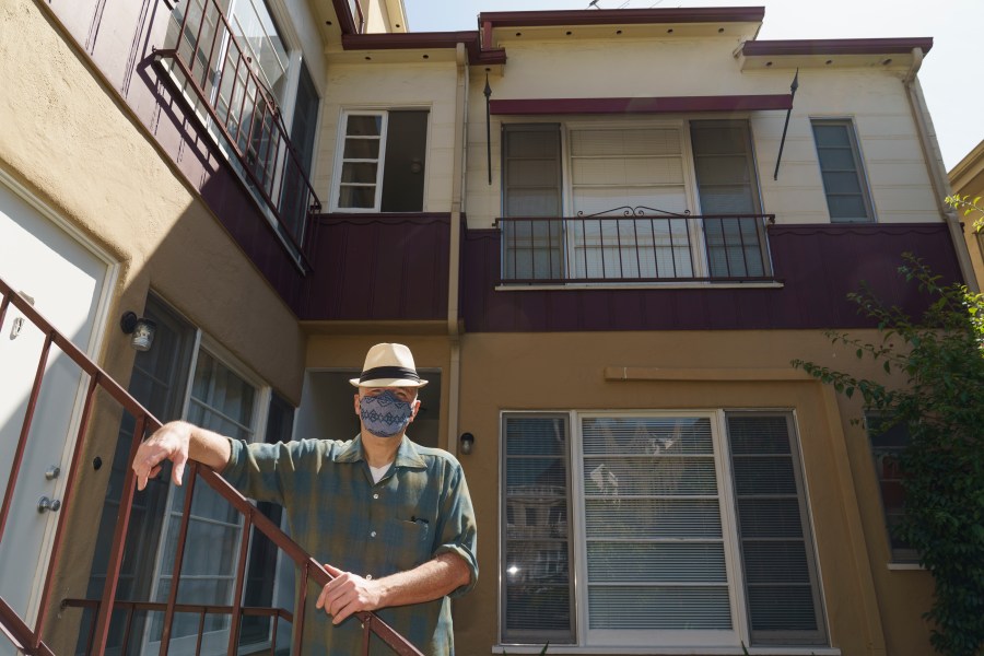 Nathan Long, a video game writer, poses for a picture outside his rental apartment courtyard in Glendale on April 8, 2021. He and his wife, Lili, have been unsuccessful so far in their search for a home in Los Angeles. (AP Photo/Damian Dovarganes)