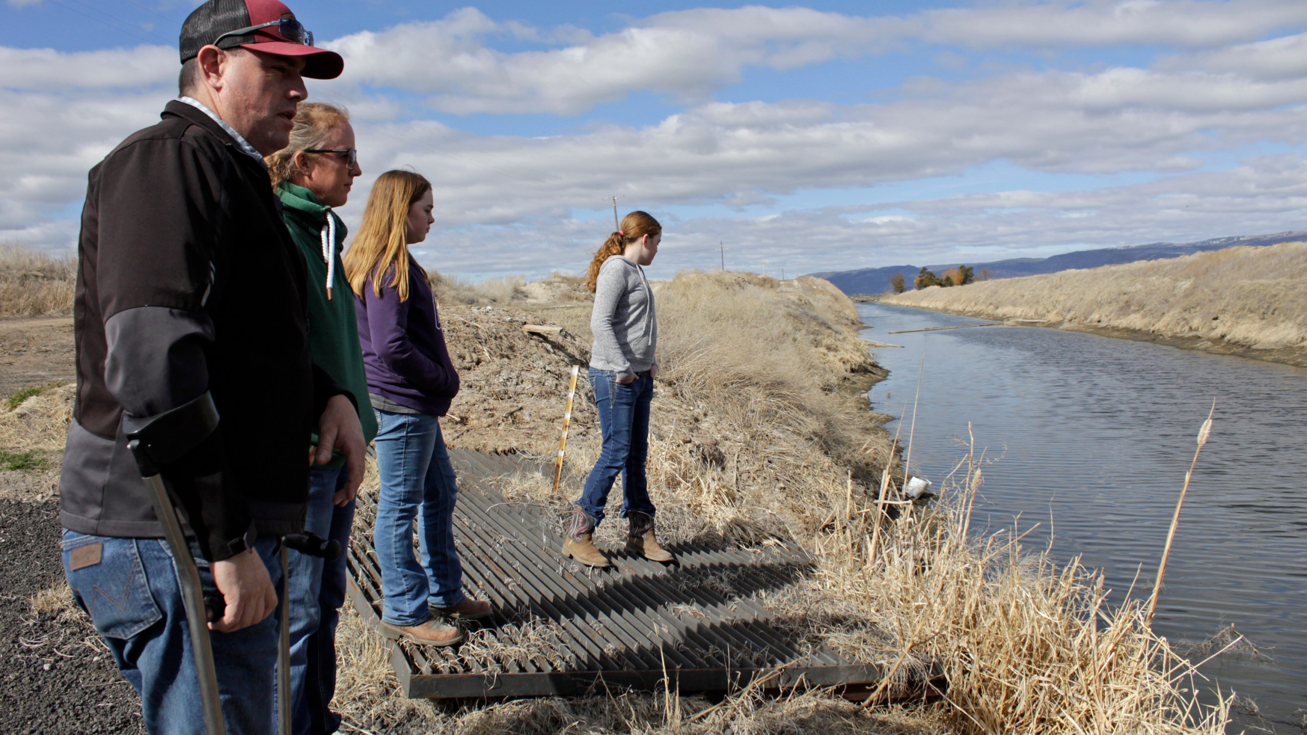 In this March 2, 2020, file photo, farmer Ben DuVal with his wife, Erika, and their daughters, Hannah, third from left, and Helena, fourth from left, stand near a canal for collecting run-off water near their property in Tulelake, Calif. (AP Photo/Gillian Flaccus, File)