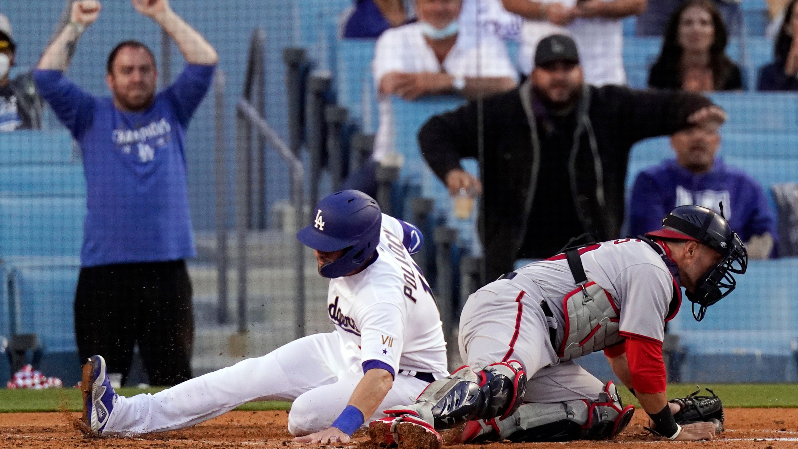 Los Angeles Dodgers' AJ Pollock, left, scores on a single by Zach McKinstry as Washington Nationals catcher Yan Gomes can't hold on to the throw during the second inning of a baseball game Saturday, April 10, 2021, in Los Angeles. (AP Photo/Mark J. Terrill)