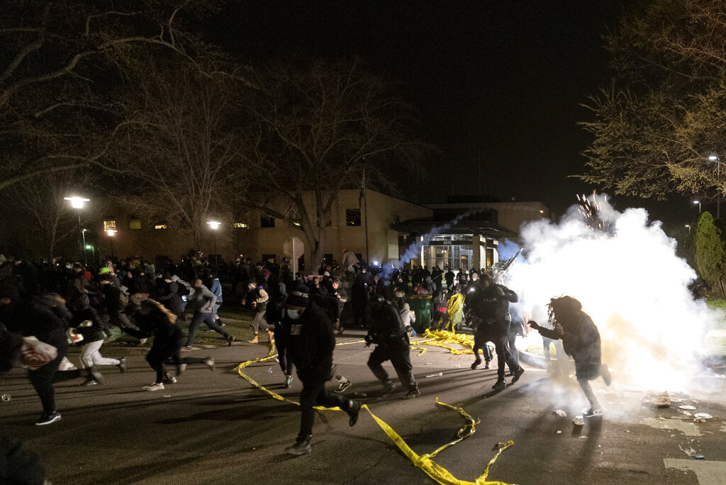 People run as police attempt to disperse the crowd at the Brooklyn Center Police Department, late Sunday, April 11, 2021, in Brooklyn Center, Minn. (Carlos Gonzalez/Star Tribune via AP)