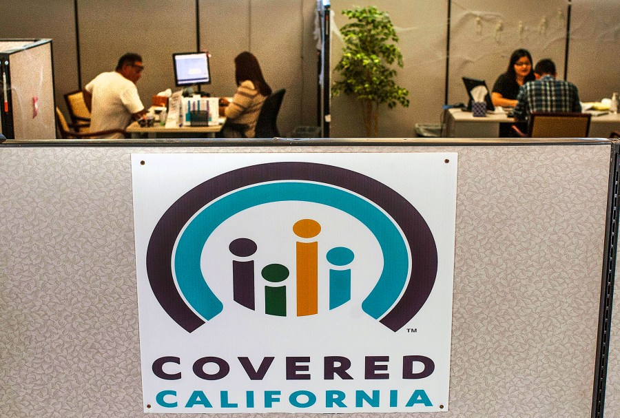 In this Nov. 1, 2016, file photo, agents help sign people up for insurance through the Covered California exchange at their storefront in Huntington Beach, Calif. (Nick Agro/The Orange County Register via AP, File)