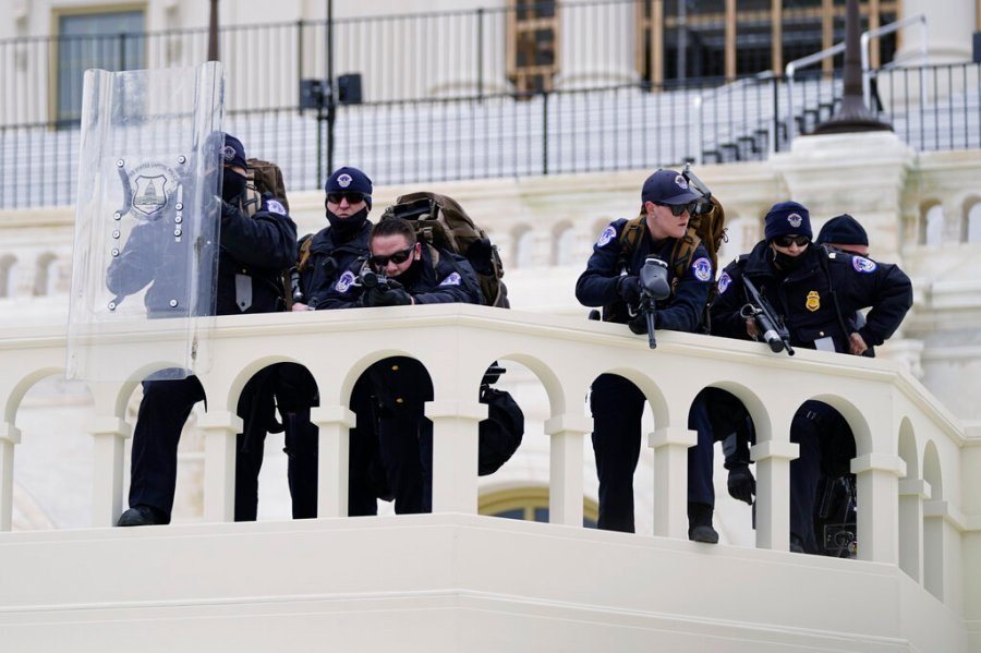 In this Jan. 6, 2021, file photo, police keep a watch on demonstrators who tried to break through a police barrier at the Capitol in Washington. (AP Photo/Julio Cortez, File)