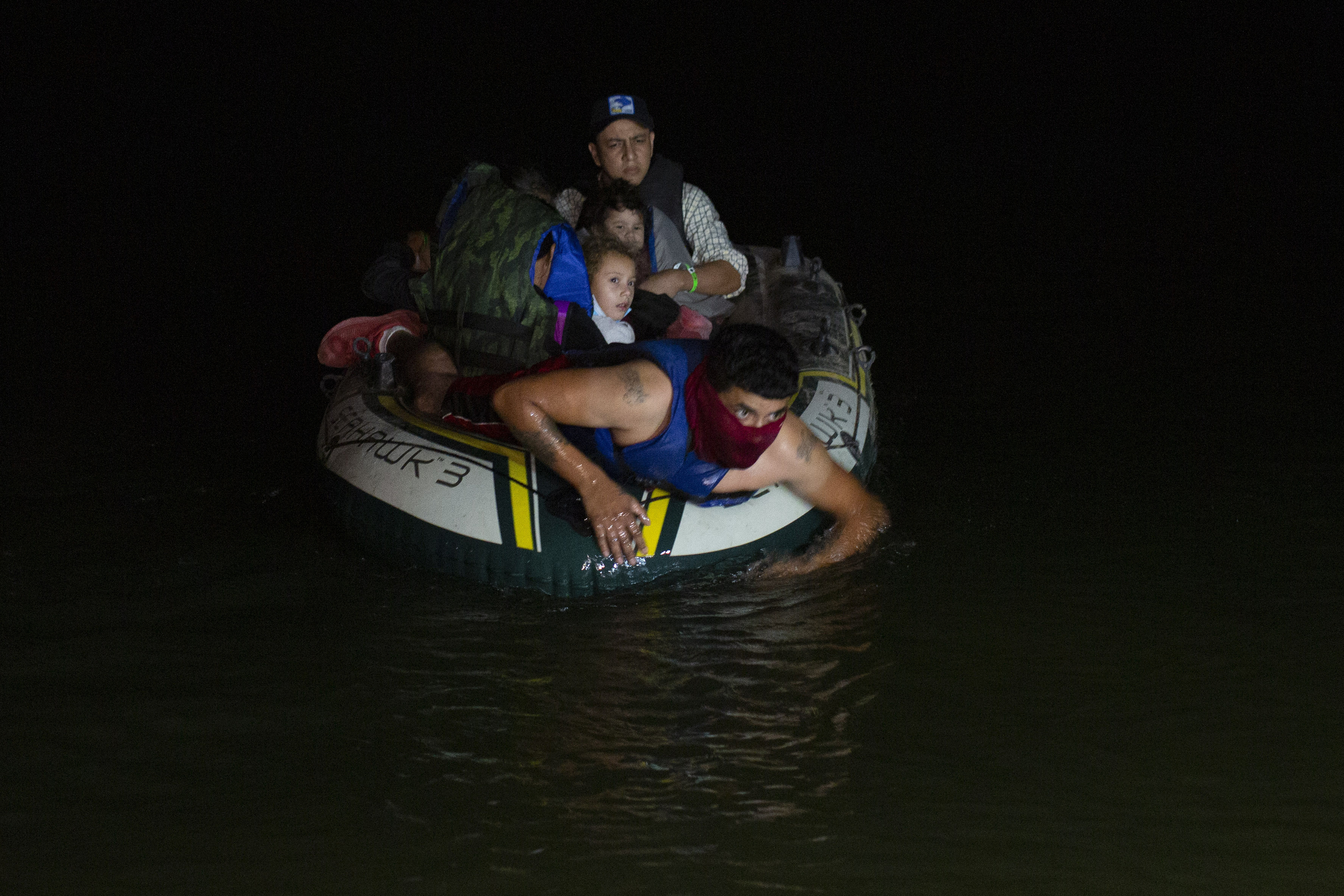 In this March 30, 2021 file photo, a smuggler takes migrants, mostly from Central American countries, on a small inflatable raft towards U.S. soil, in Roma, Texas. (Dario Lopez-Mills, Associated Press)