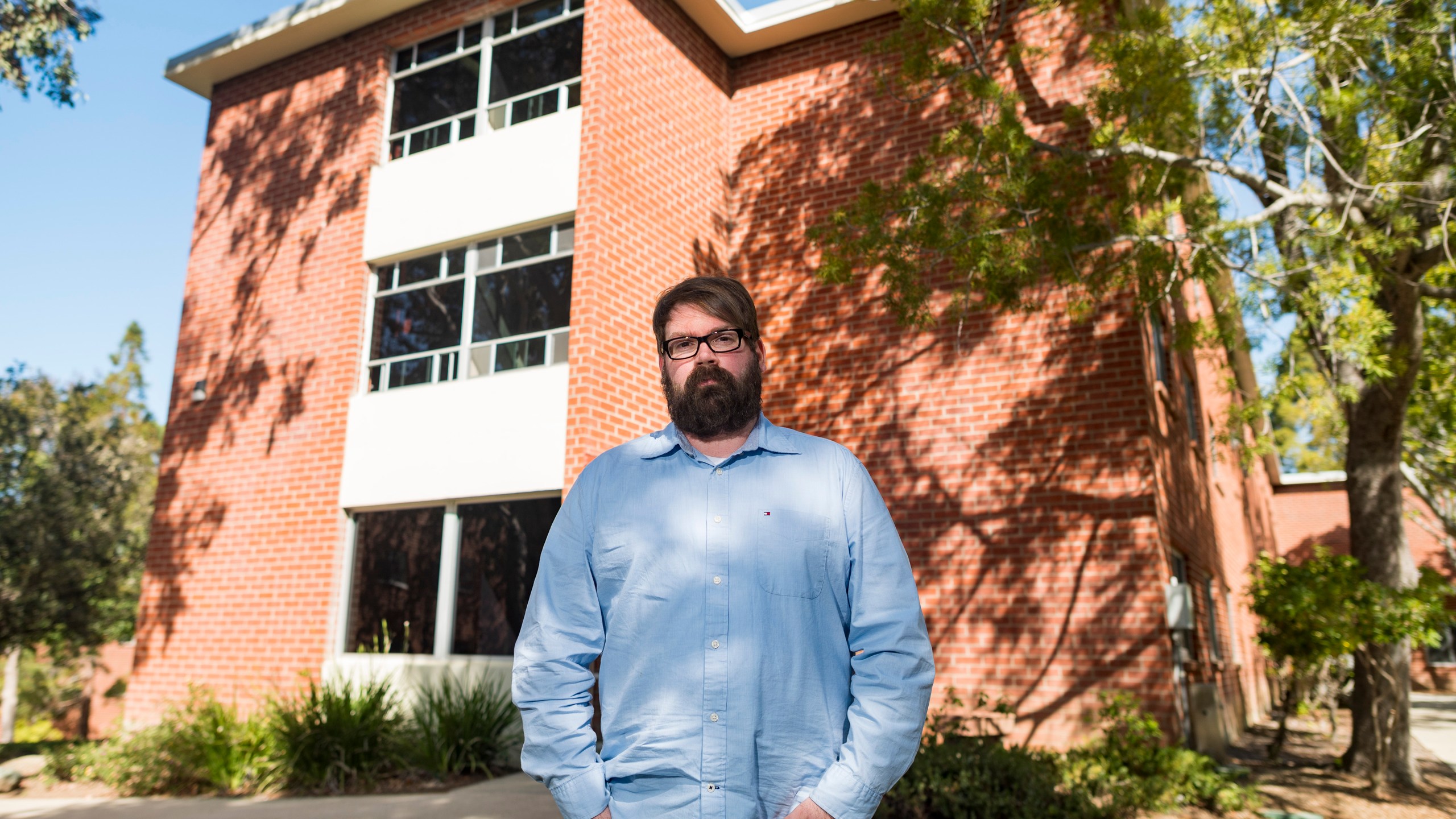 Chris Lambert, a musician and recording engineer, poses on April 15, 2021, in front of Muir Hall dormitory at California Polytechnic University in San Luis Obispo. (Nic Coury / Associated Press)