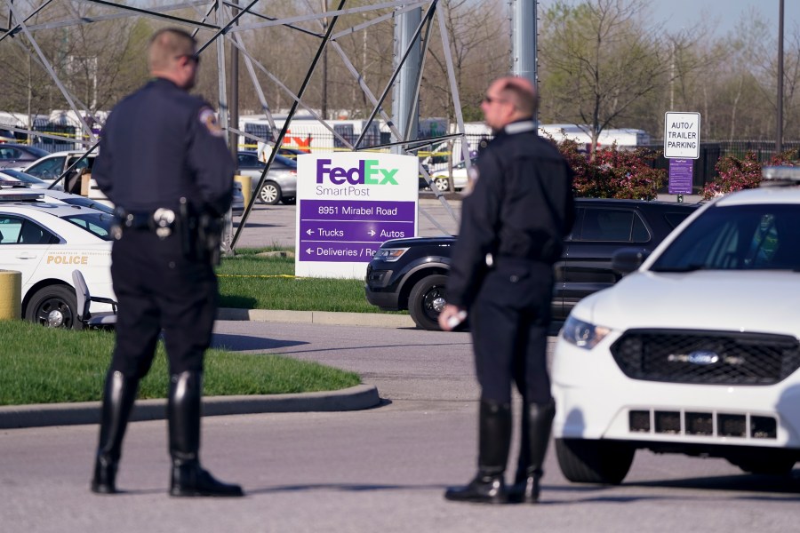 Police stand near the scene where multiple people were shot at the FedEx Ground facility early Friday morning, April 16, 2021, in Indianapolis. (AP Photo/Michael Conroy)