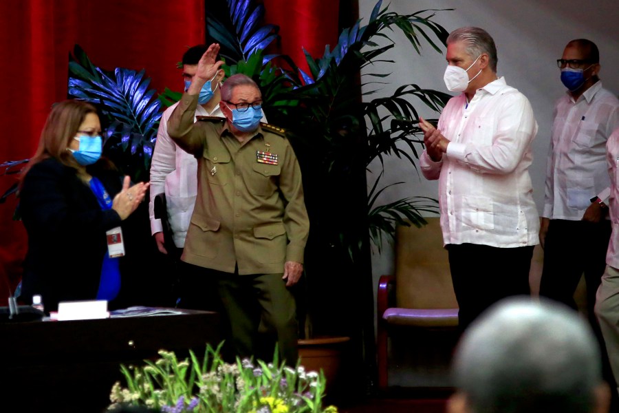 Raul Castro, first secretary of the Communist Party and former president, waves to members at the VIII Congress of the Communist Party of Cuba's opening session, as Cuban President Miguel Diaz-Canel, right, applauds at the Convention Palace, in Havana, Cuba, Friday, April 16, 2021. (Ariel Ley Royero/ACN via AP)