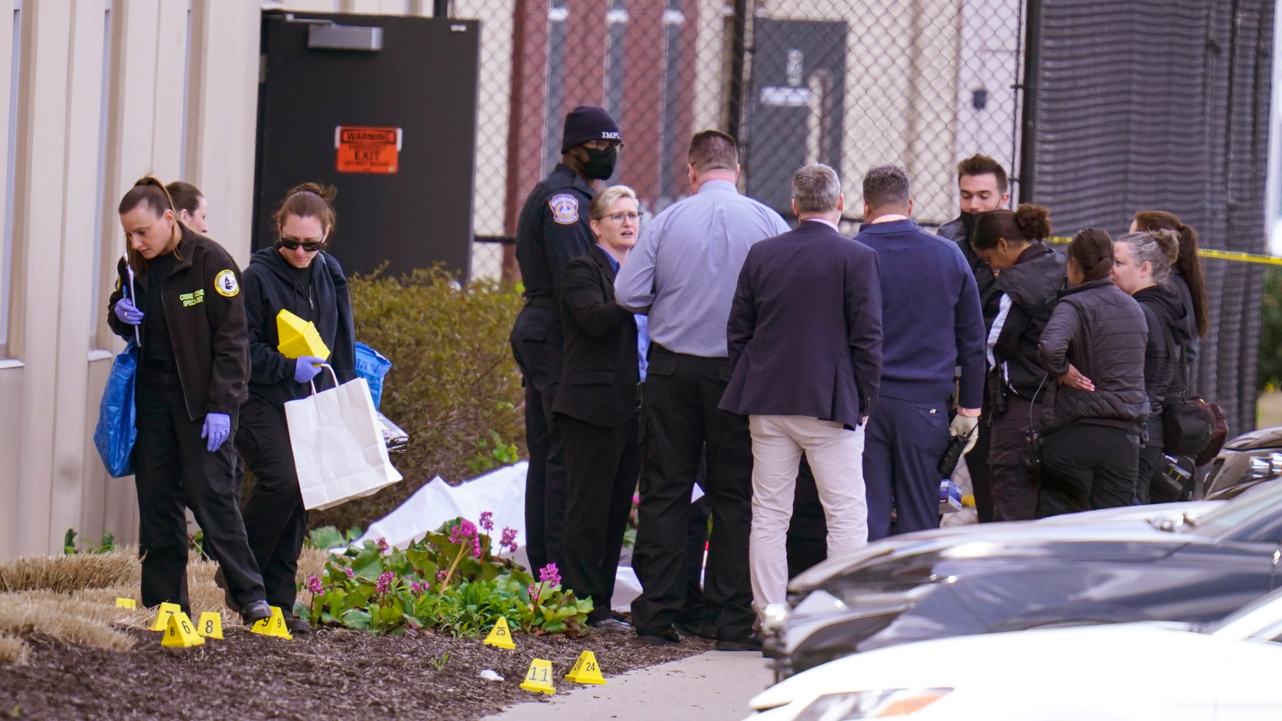 Authorities confer at the scene where multiple people were shot at the FedEx Ground facility early Friday morning, April 16, 2021, in Indianapolis. A gunman killed several people and wounded others before taking his own life in a late-night attack at a FedEx facility near the Indianapolis airport, police said. (AP Photo/Michael Conroy)