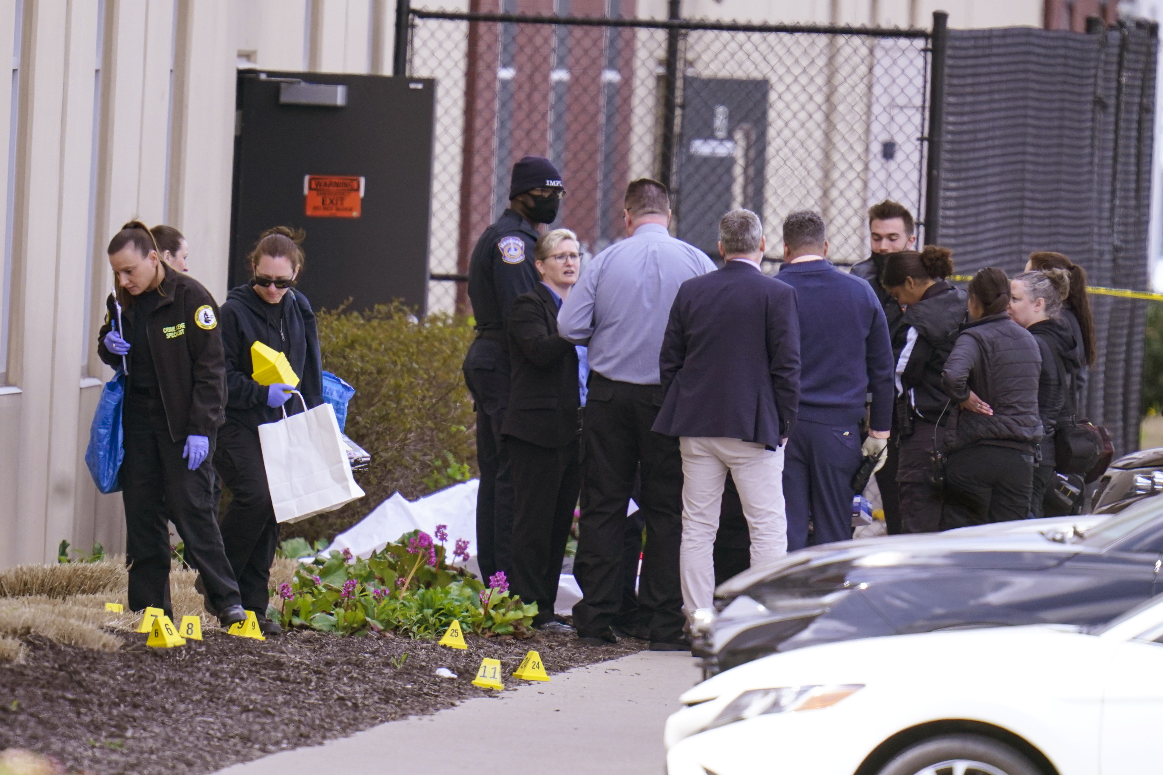 Authorities confer at the scene where multiple people were shot at the FedEx Ground facility early Friday morning, April 16, 2021, in Indianapolis. A gunman killed several people and wounded others before taking his own life in a late-night attack at a FedEx facility near the Indianapolis airport, police said. (AP Photo/Michael Conroy)