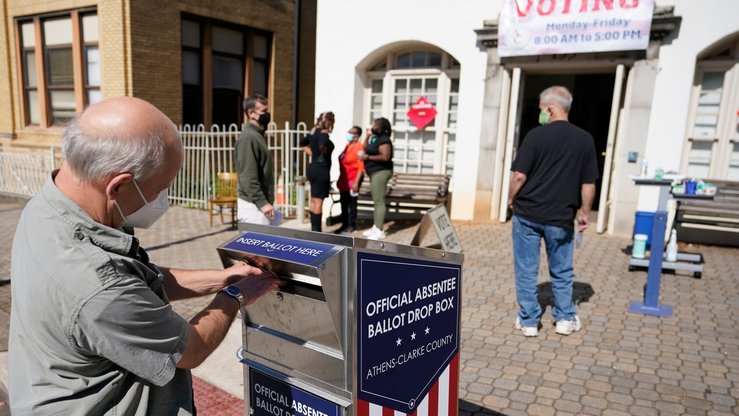 In this Monday, Oct. 19, 2020 file photo, a voter submits a ballot in an official drop box during early voting in Athens, Ga. Ballot drop boxes were enormously popular during the 2020 election, with few problems reported. Yet they have drawn the attention of Republican lawmakers in key states who say security concerns warrant new restrictions. (AP Photo/John Bazemore, File)