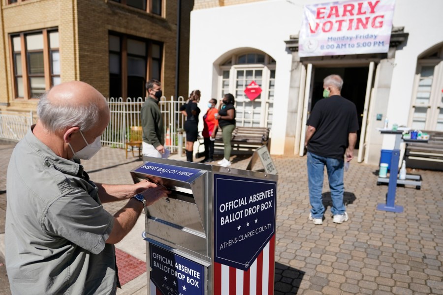 In this Monday, Oct. 19, 2020 file photo, a voter submits a ballot in an official drop box during early voting in Athens, Ga. Ballot drop boxes were enormously popular during the 2020 election, with few problems reported. Yet they have drawn the attention of Republican lawmakers in key states who say security concerns warrant new restrictions. (AP Photo/John Bazemore, File)