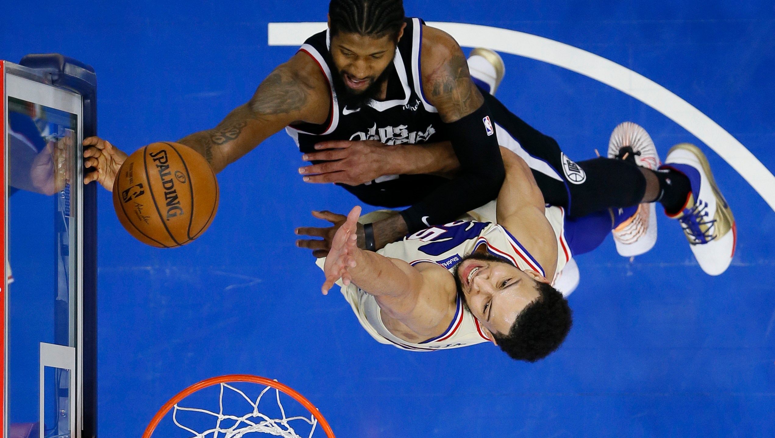 Los Angeles Clippers' Paul George, top, goes up for a shot against Philadelphia 76ers' Ben Simmons during the second half of an NBA basketball game in Philadelphia April 16, 2021. (Matt Slocum / Associated Press)