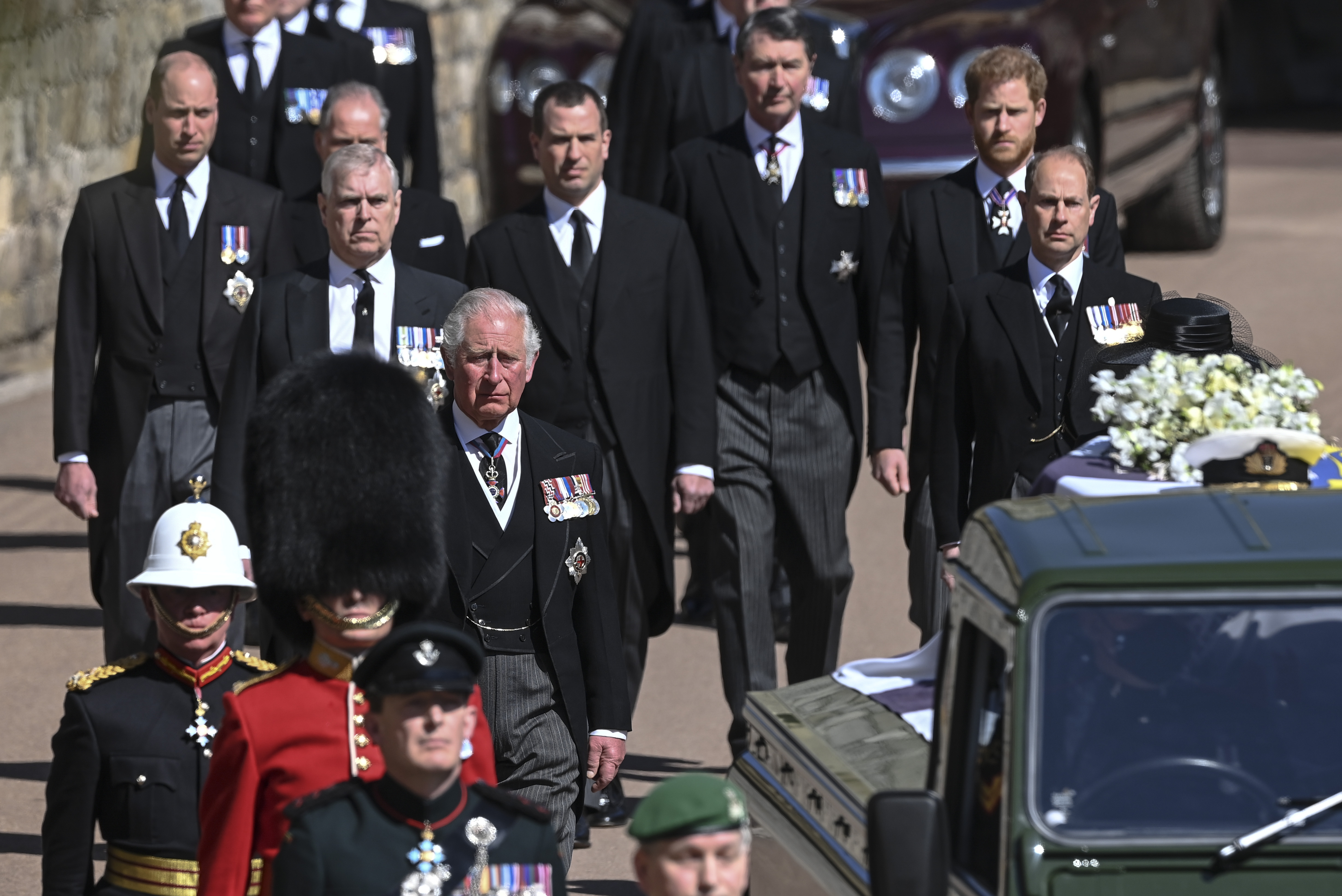 From front left, Britain's Prince Charles, Prince Andrew. Prince Edward, Prince William, Peter Phillips, Prince Harry, Earl of Snowdon and Tim Laurence follow the coffin the coffin makes it's way past the Round Tower during the funeral of Britain's Prince Philip inside Windsor Castle in Windsor, England Saturday April 17, 2021. (Leon Neal/Pool via AP)