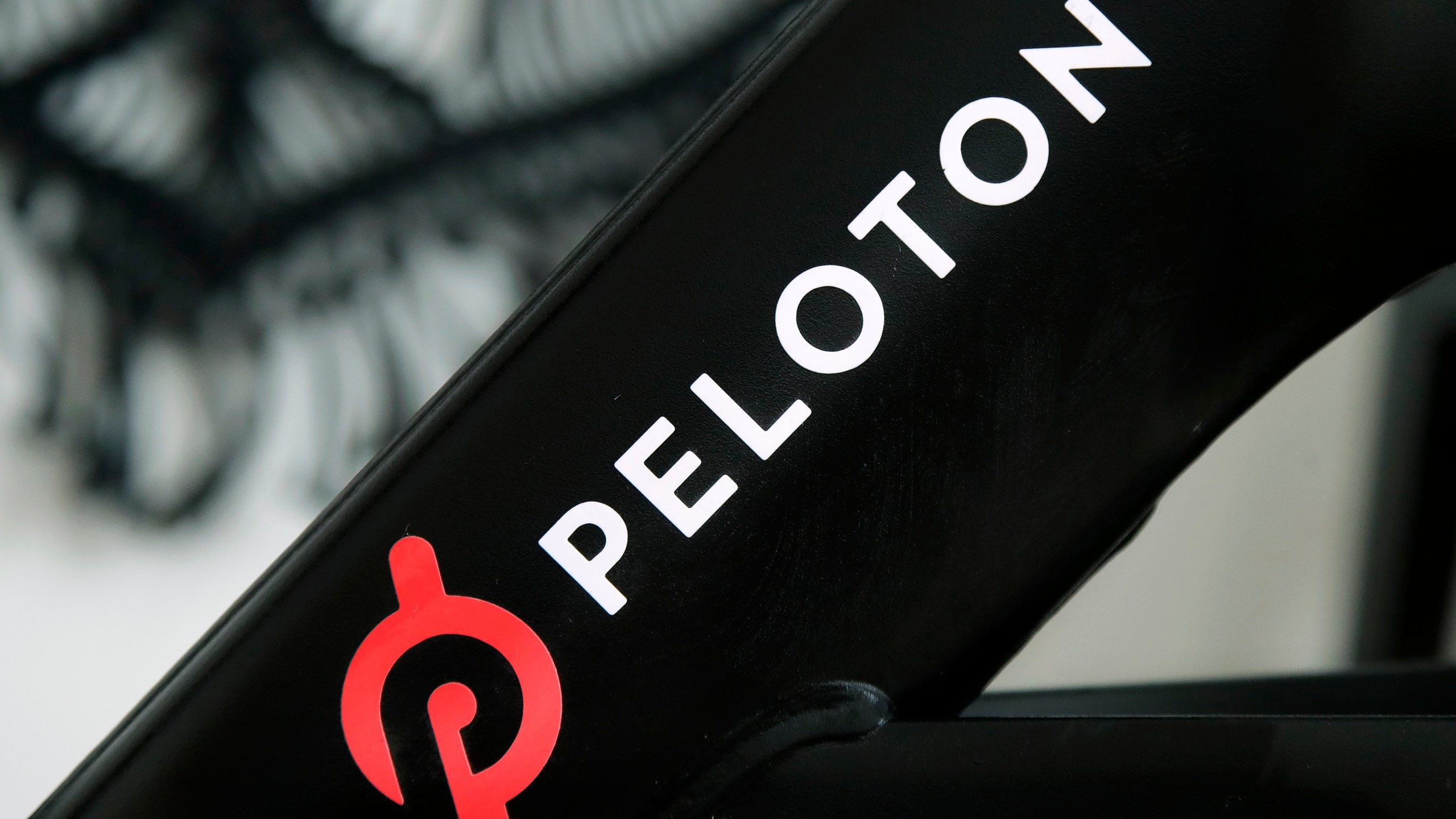 This Nov. 19, 2019 file photo shows a Peloton logo on the company's stationary bicycle in San Francisco. (AP Photo/Jeff Chiu, File)