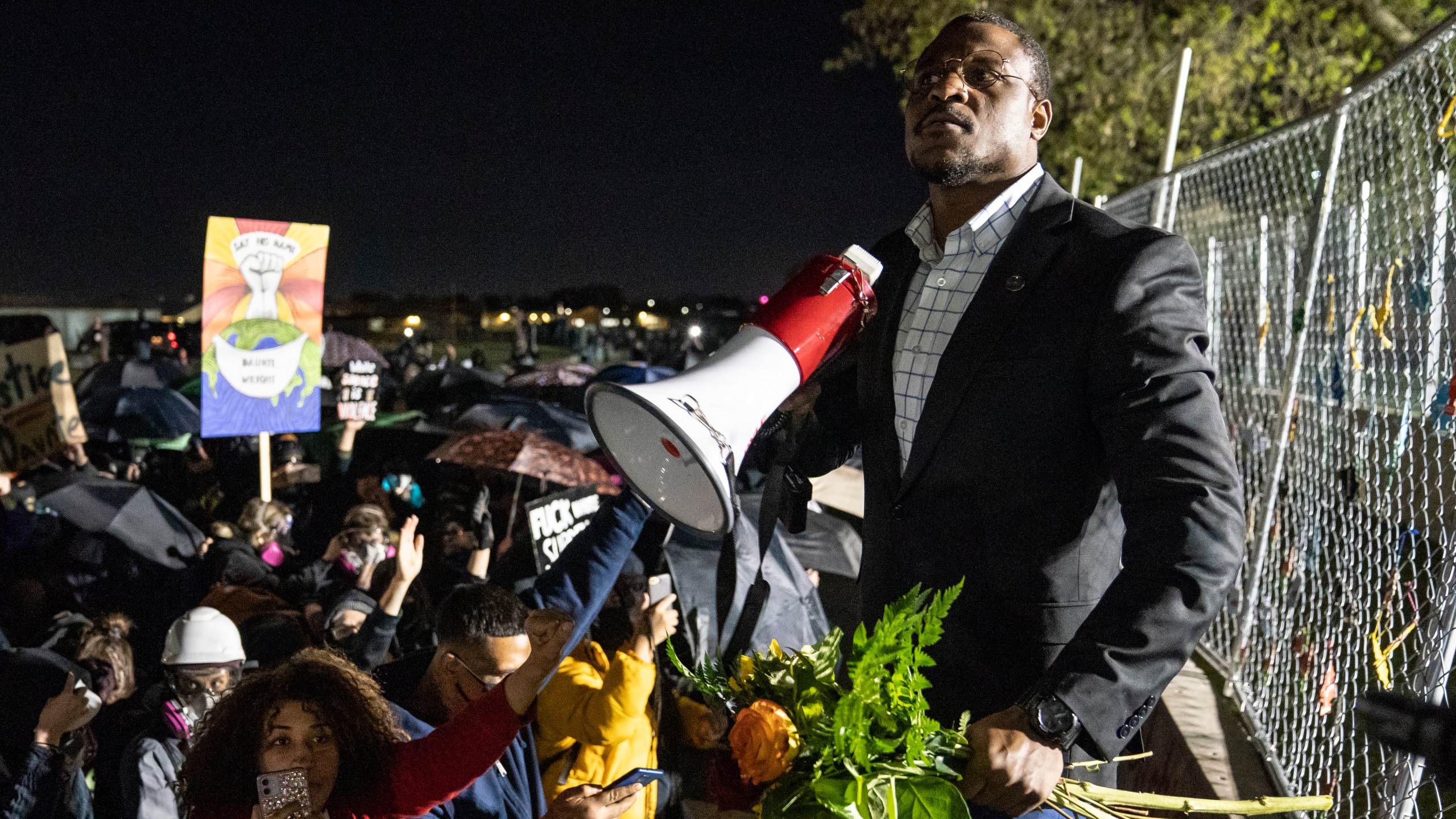 Michael Odiari leads a chant as he attempts to deescalate an altercation between demonstrators and police during a protest decrying the shooting death of Daunte Wright outside the Brooklyn Center Police Department, Friday, April 16, 2021, in Brooklyn Center, Minn. (AP Photo/John Minchillo)