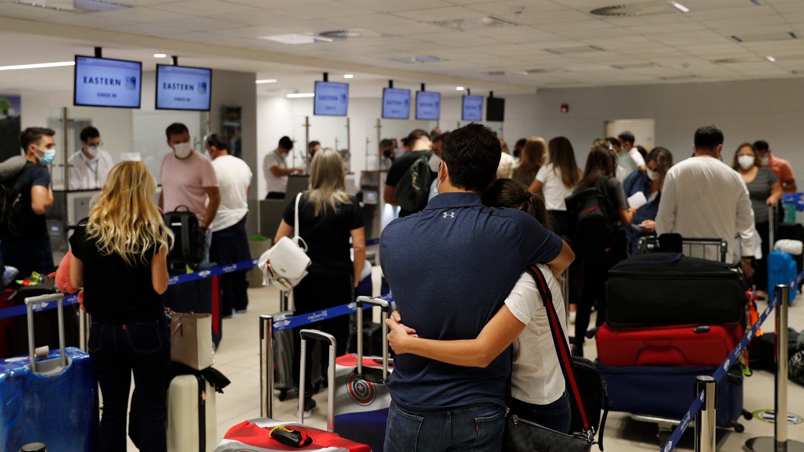 FILE - In this April 17, 2021, file photo, people check in for a flight to Miami at Silvio Pettirossi Airport, in Luque, Paraguay. Vaccine seekers who can afford to travel are coming to the United States to avoid the long wait, including people who have come from as far as Paraguay. (AP Photo/Jorge Saenz, File)