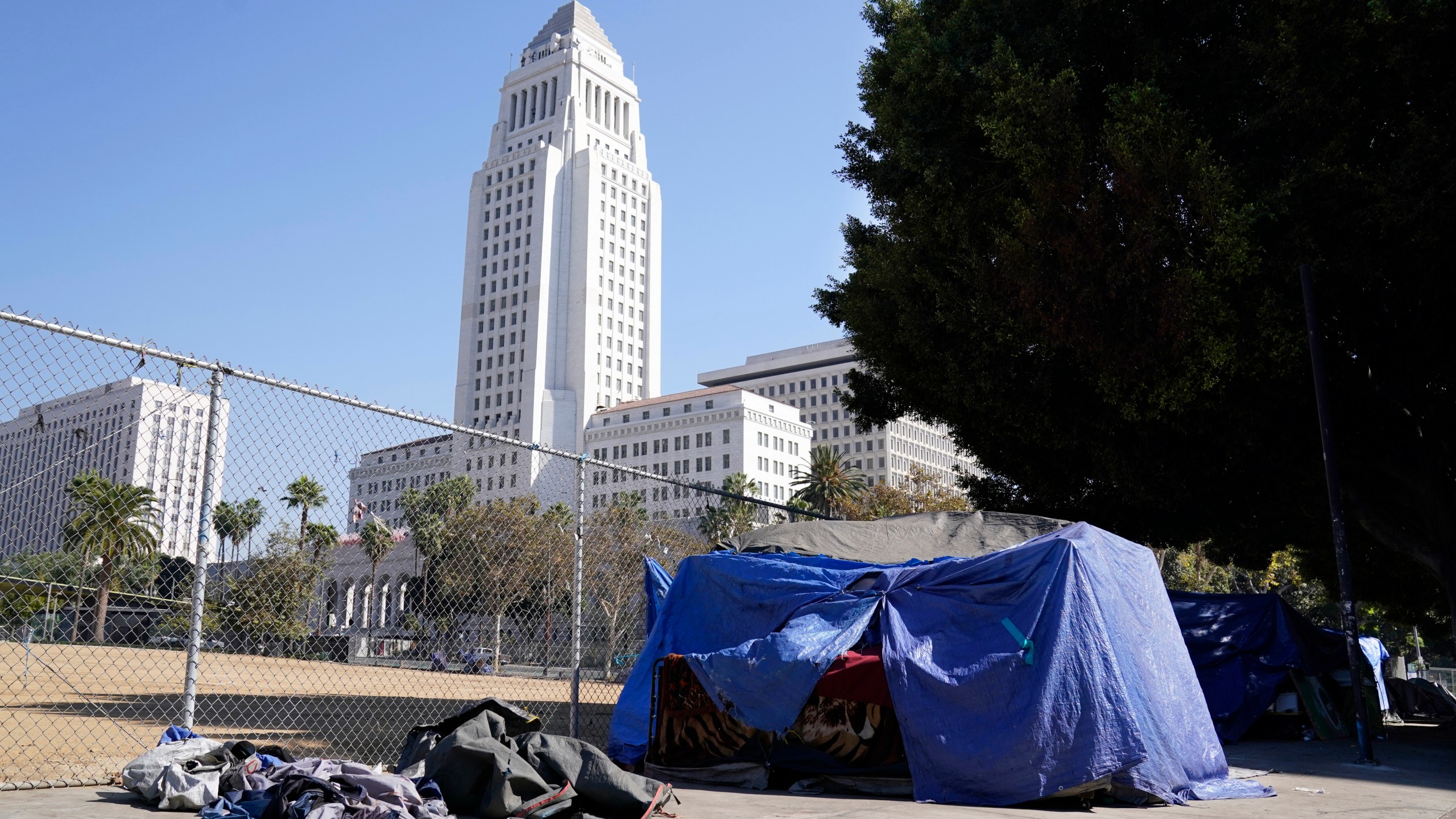 A homeless person's tent stands just outside Grand Park with Los Angeles City Hall in the background on Oct. 28, 2020. (Chris Pizzello / Associated Press)