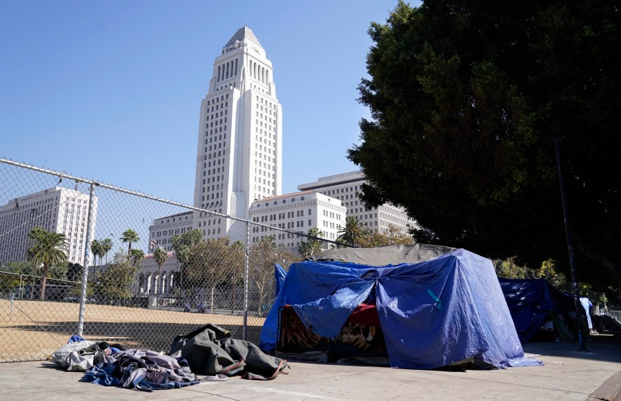 A homeless person's tent stands just outside Grand Park with Los Angeles City Hall in the background on Oct. 28, 2020. (Chris Pizzello / Associated Press)