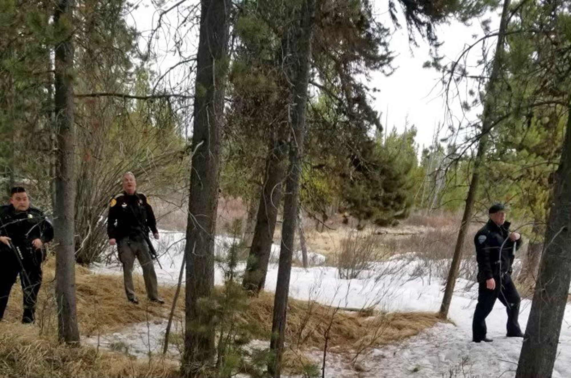 In this photo provided by the Gallatin County Sheriff's Office, officers from the sheriff's office and West Yellowstone Police Department are seen near the scene of a grizzly bear mauling just outside Yellowstone National Park near West Yellowstone, Mont. on April, 15, 2021. Authorities said Charles "Carl" Mock died Saturday of injuries sustained in the attack. (Gallatin County Sheriff's Office via AP)