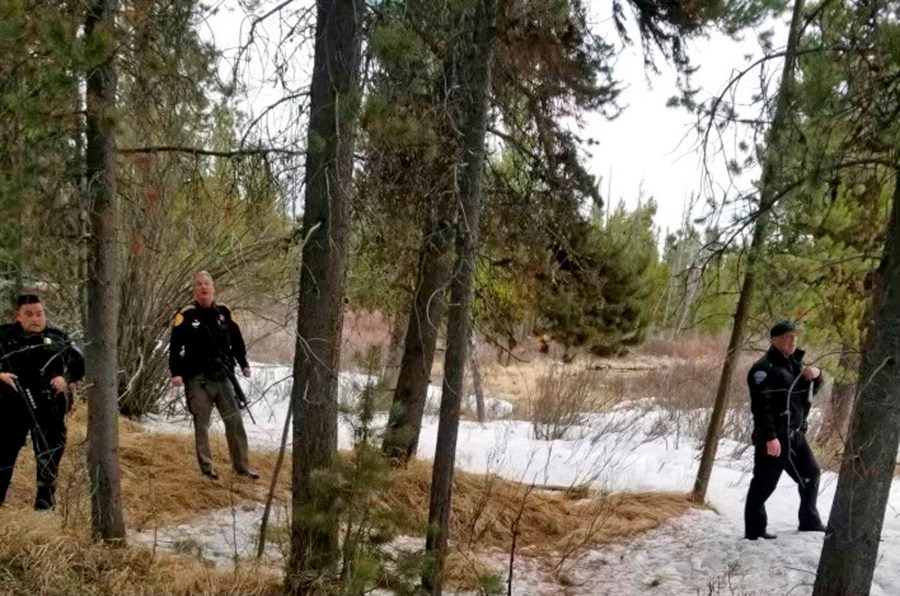 In this photo provided by the Gallatin County Sheriff's Office, officers from the sheriff's office and West Yellowstone Police Department are seen near the scene of a grizzly bear mauling just outside Yellowstone National Park near West Yellowstone, Mont. on April, 15, 2021. Authorities said Charles "Carl" Mock died Saturday of injuries sustained in the attack. (Gallatin County Sheriff's Office via AP)