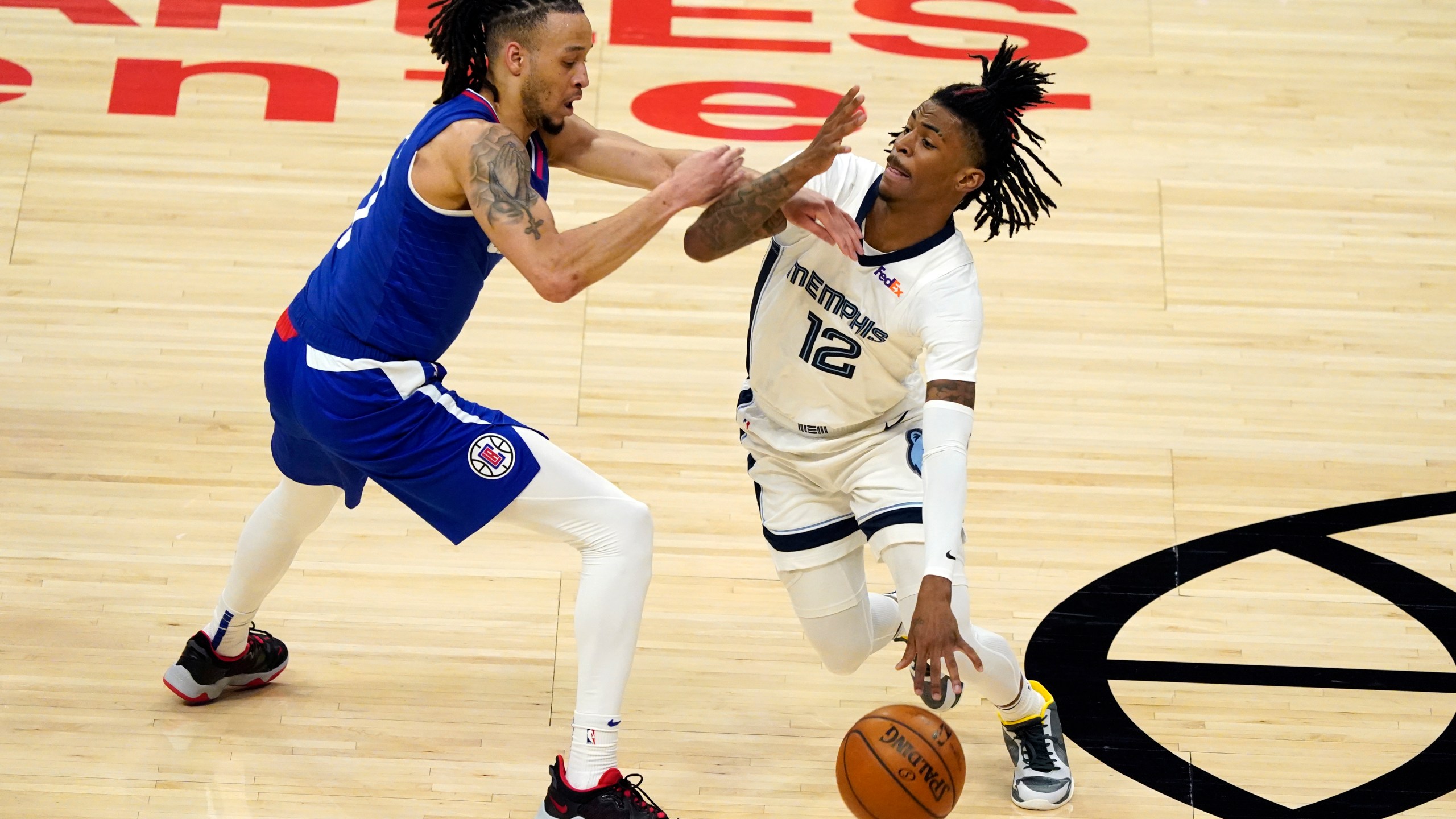 Memphis Grizzlies guard Ja Morant (12) is defended by Los Angeles Clippers guard Amir Coffey during the first half of an NBA basketball game in Los Angeles on April 21, 2021. (Marcio Jose Sanchez / Associated Press)